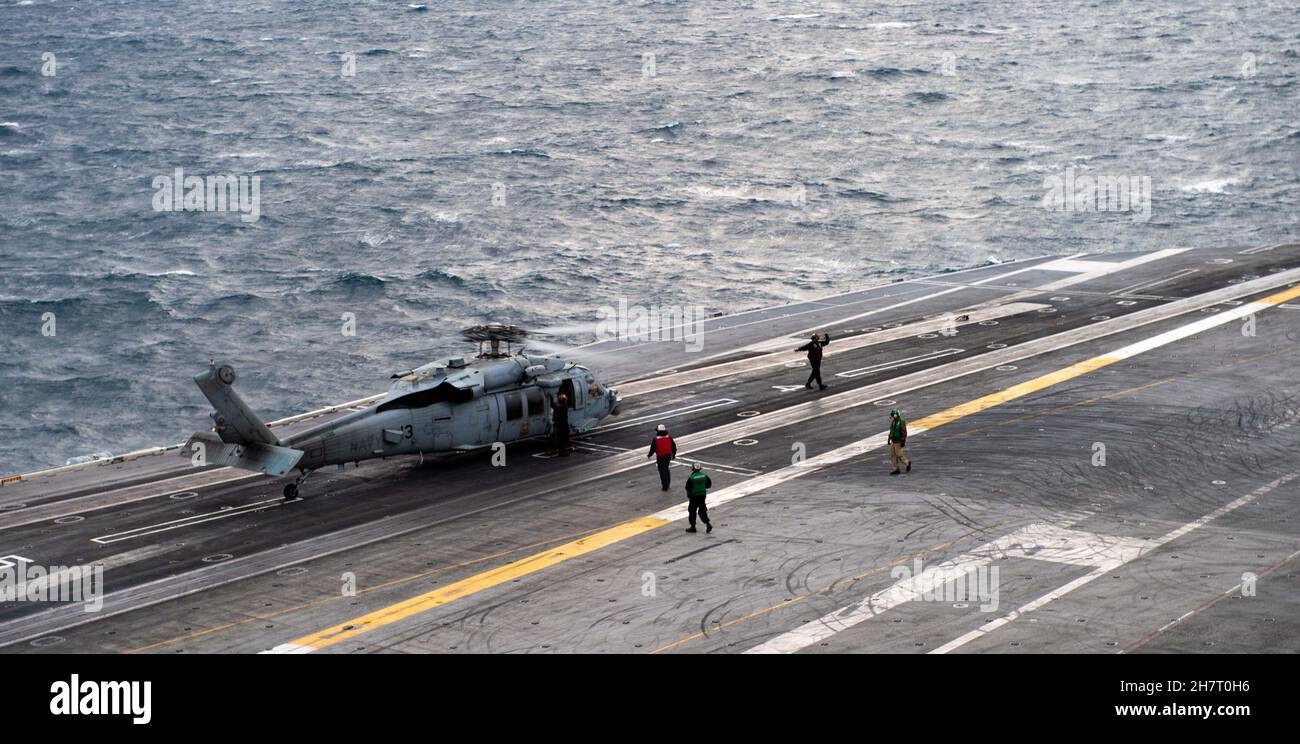 211123-N-TL932-1103 MER DES PHILIPPINES (NOV23, 2021) un Faucon de mer MH-60S, affecté à l’Escadron de combat en mer des hélicoptères des « Chevaliers noirs » (VAW) 113, atterrit sur le pont de vol du porte-avions de la classe Nimitz USS Carl Vinson (CVN 70), le 23 novembre 2021.Carl Vinson Carrier Strike Group est en cours de déploiement prévu dans la zone d'exploitation de la 7e flotte des États-Unis afin d'améliorer l'interopérabilité par le biais d'alliances et de partenariats tout en servant de force d'intervention prête à l'emploi pour soutenir une région Indo-Pacifique libre et ouverte.(É.-U.Photo de la marine par le spécialiste en communication de masse apprenti marin Joshua SAPIEN Banque D'Images