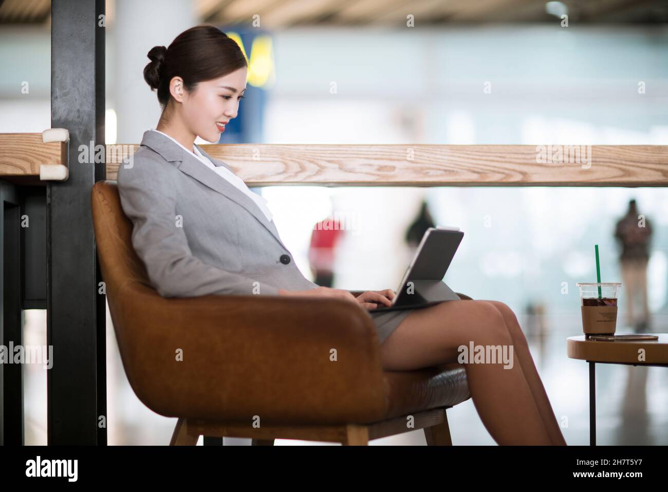 Jeune femme d'affaires utilisant un ordinateur portable dans un café d'aéroport Banque D'Images