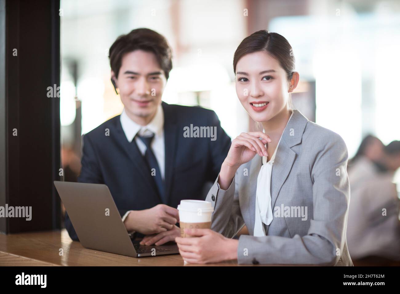 Jeune femme d'affaires utilisant un ordinateur portable dans un café d'aéroport Banque D'Images