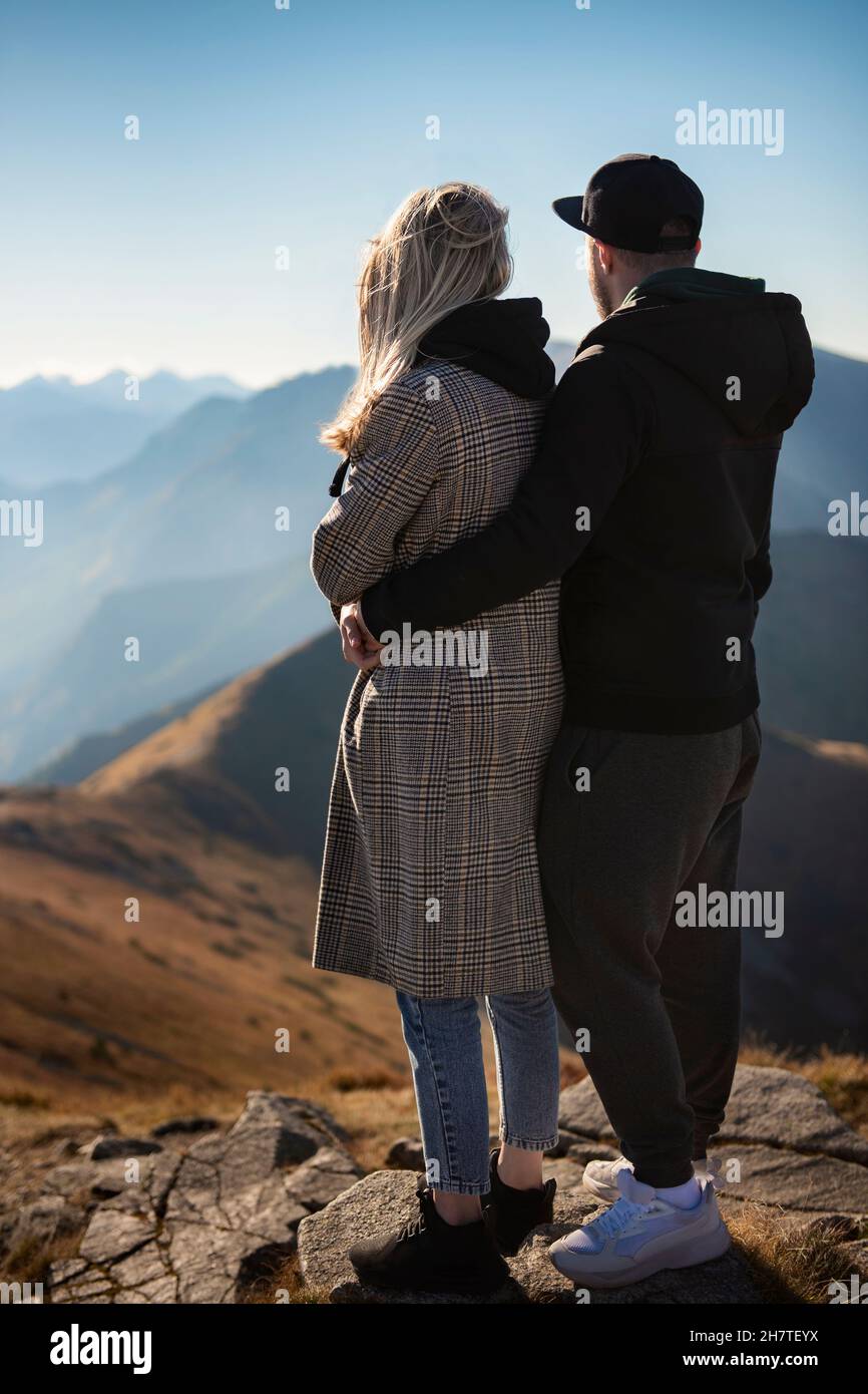 Un jeune couple heureux qui fait une pause lors d'une randonnée dans les montagnes Banque D'Images