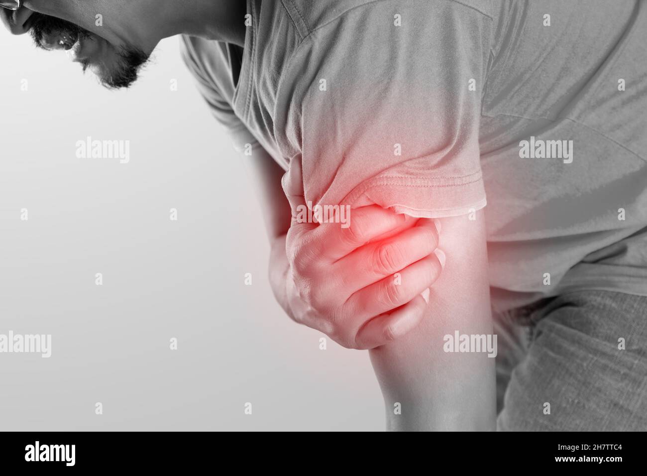 L'homme asiatique dont le muscle de la partie supérieure du bras est douloureux sur fond gris Banque D'Images