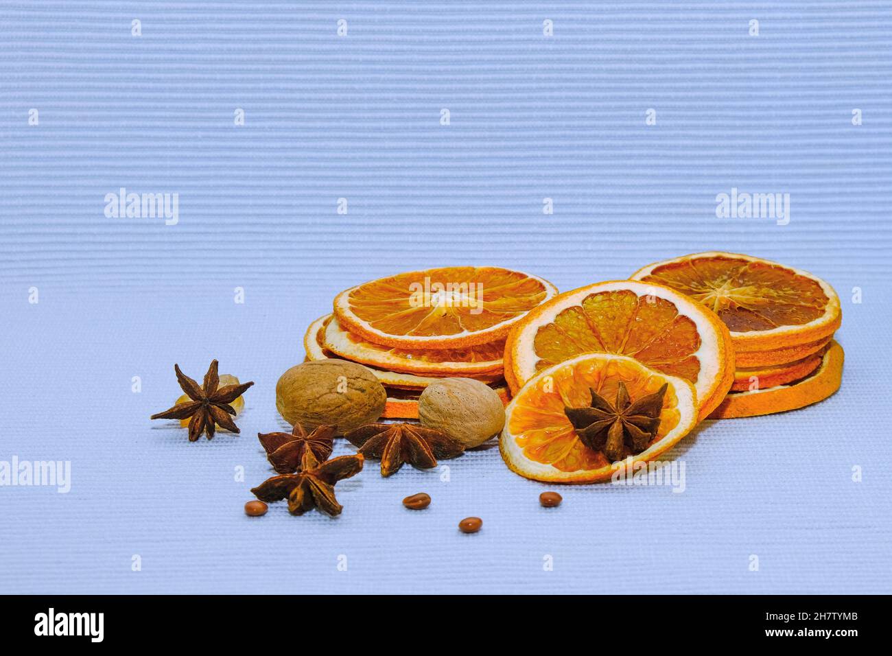 Tranches d'orange et de pamplemousse séchés, de noix de muscade et d'anis étoilé pour les décorations de noël sur fond bleu clair. Banque D'Images