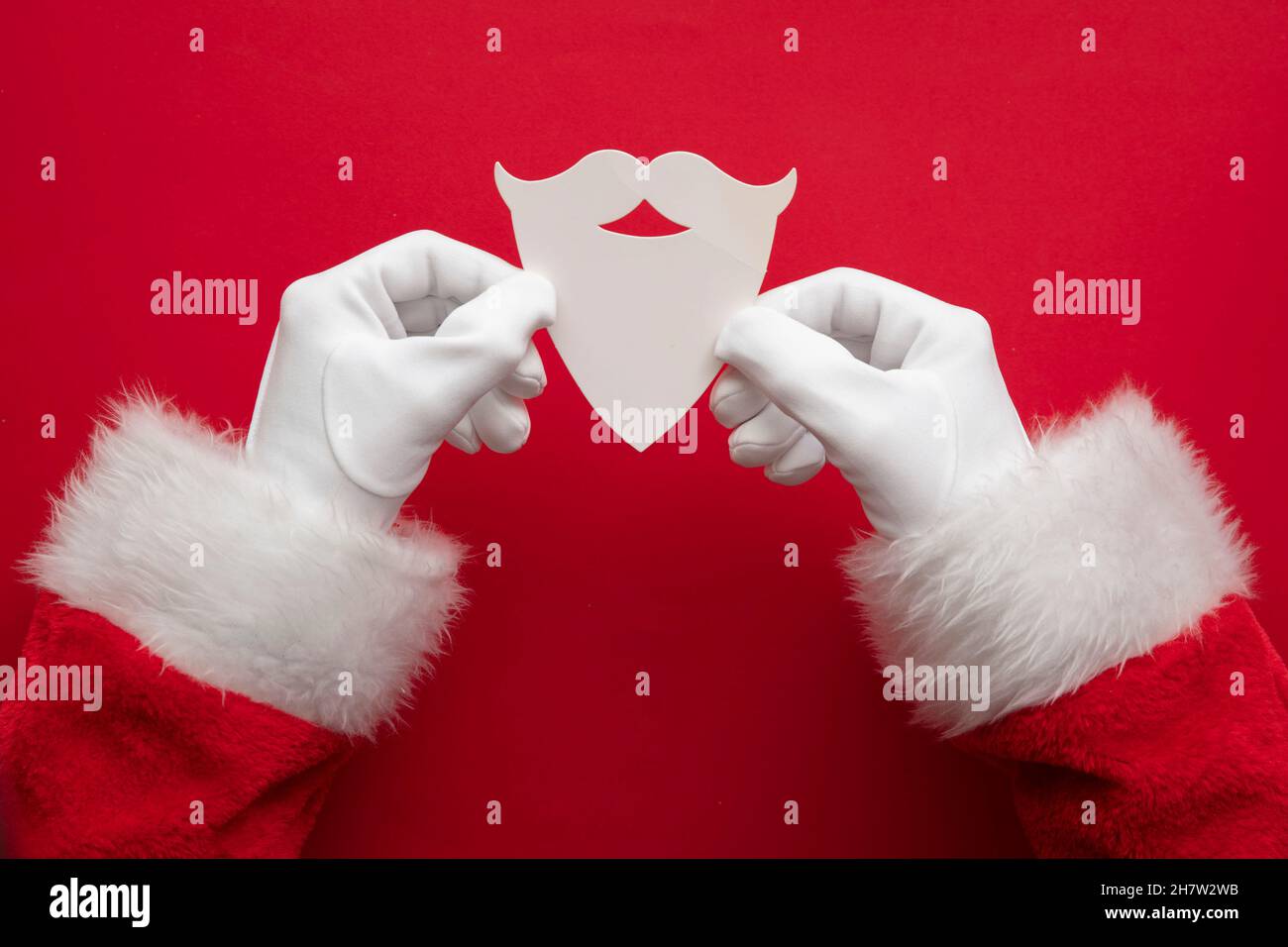 Les mains du Père Noël ont une barbe de Noël blanche et une moustache en papier Banque D'Images