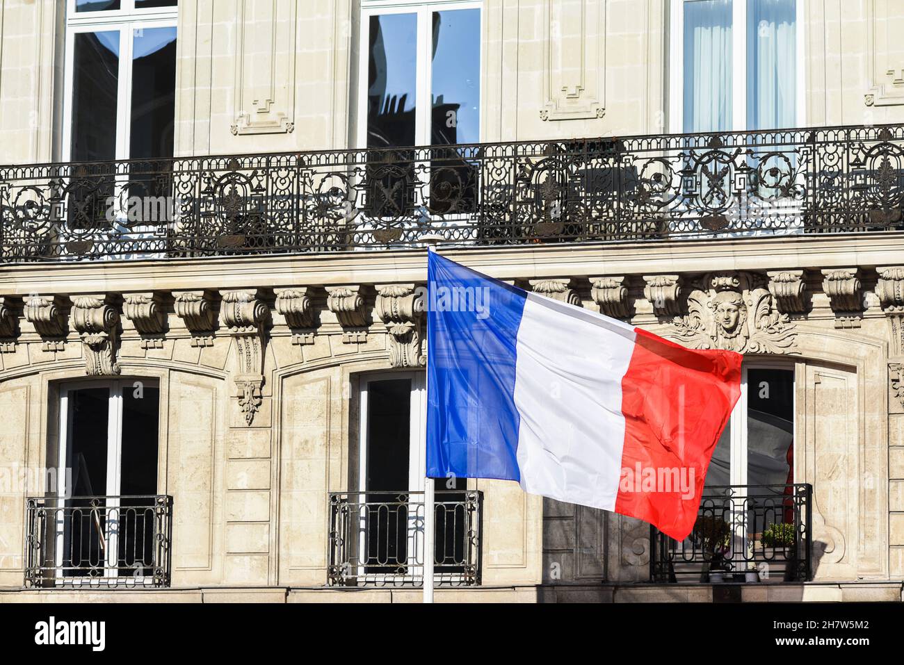 Le drapeau français accroché à la maison du bâtiment, agitant dans le vent. Banque D'Images