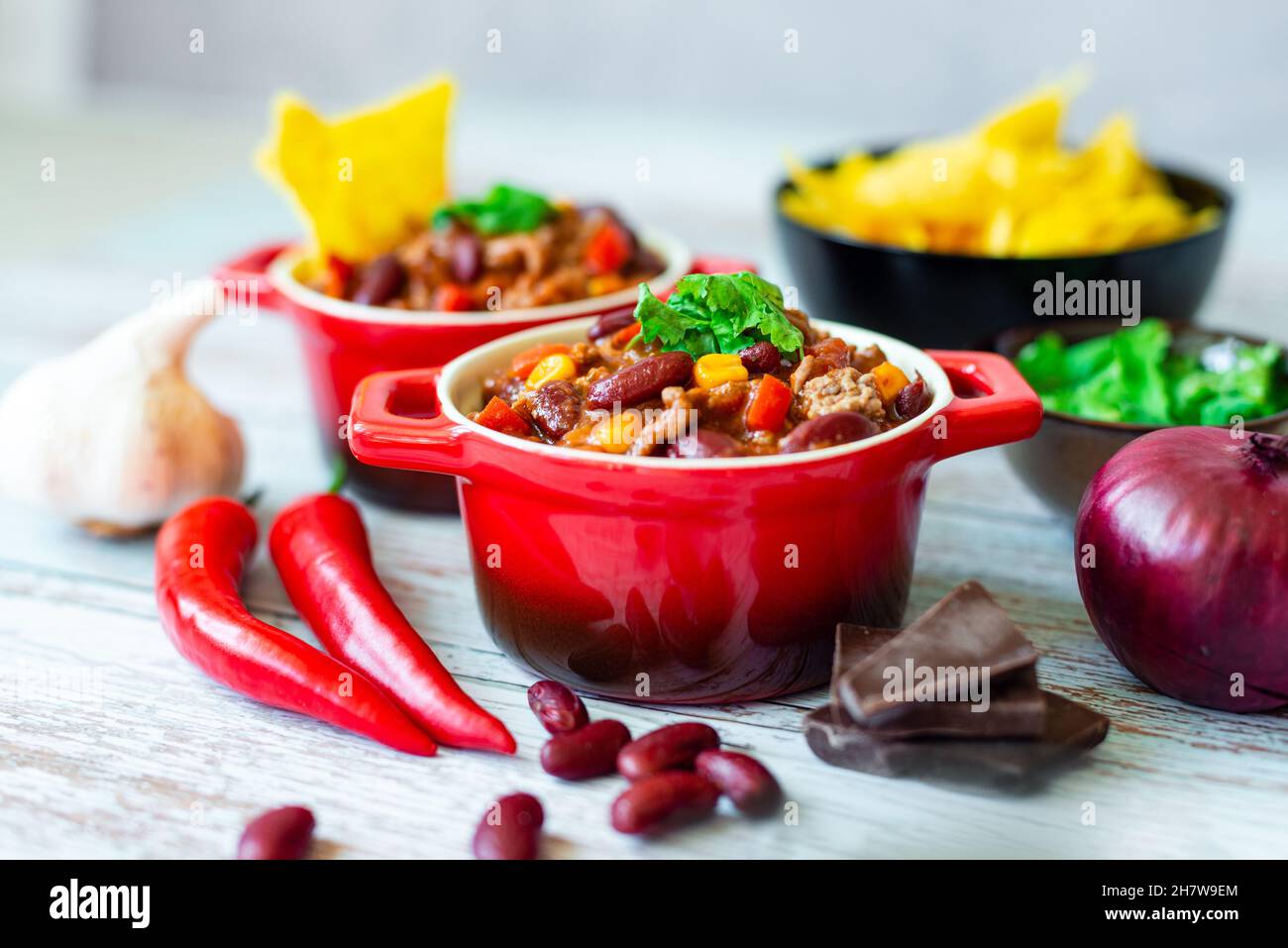 Délicieux Chili con carne dans des pots rouges servis avec une partie de croustilles tortilla Banque D'Images