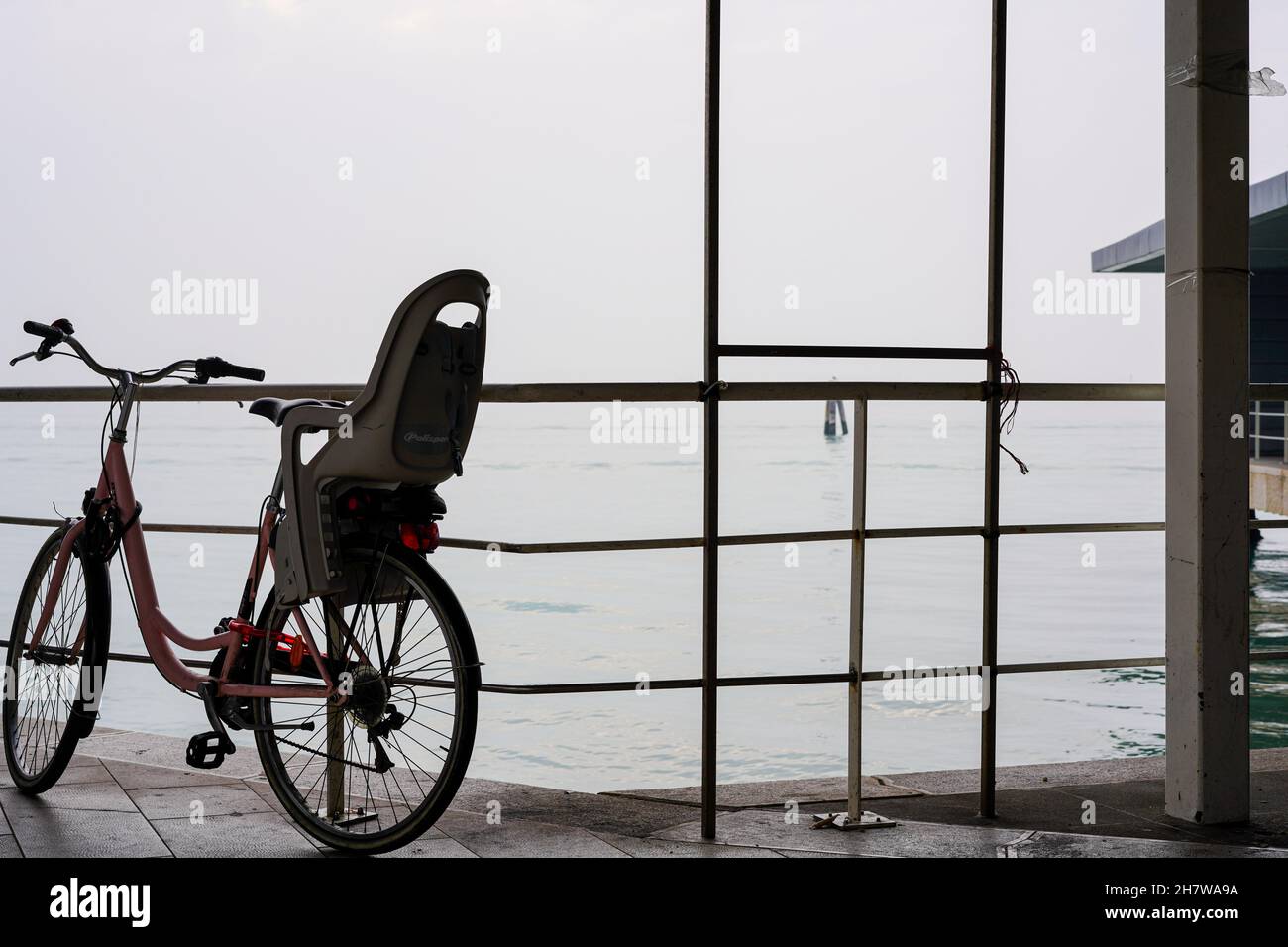 Bicyclette garée avec siège enfant au port du Lido, île dans la lagune de Venise. Banque D'Images