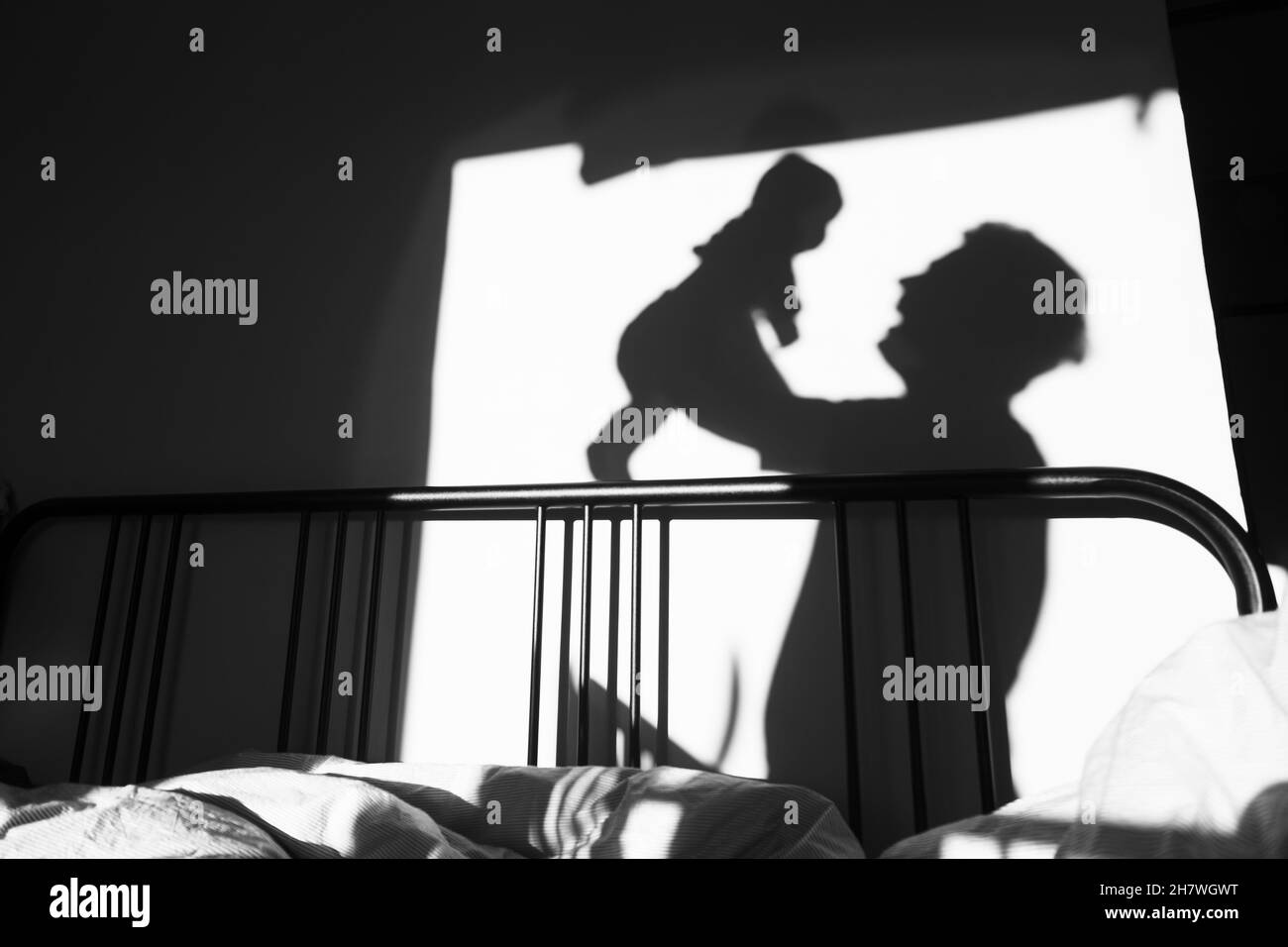 silhouette d'un enfant et d'un parent qui jouent dans la chambre le matin. Banque D'Images