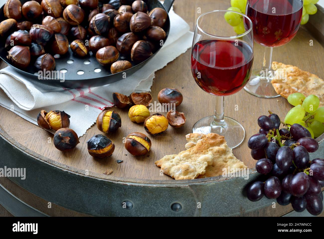 Dégustation de vins dans le Tyrol du Sud avec des châtaignes grillées et le pain de seigle local croquant, appelé Schuettelbrot, servi sur un vieux tonneau de vin Banque D'Images