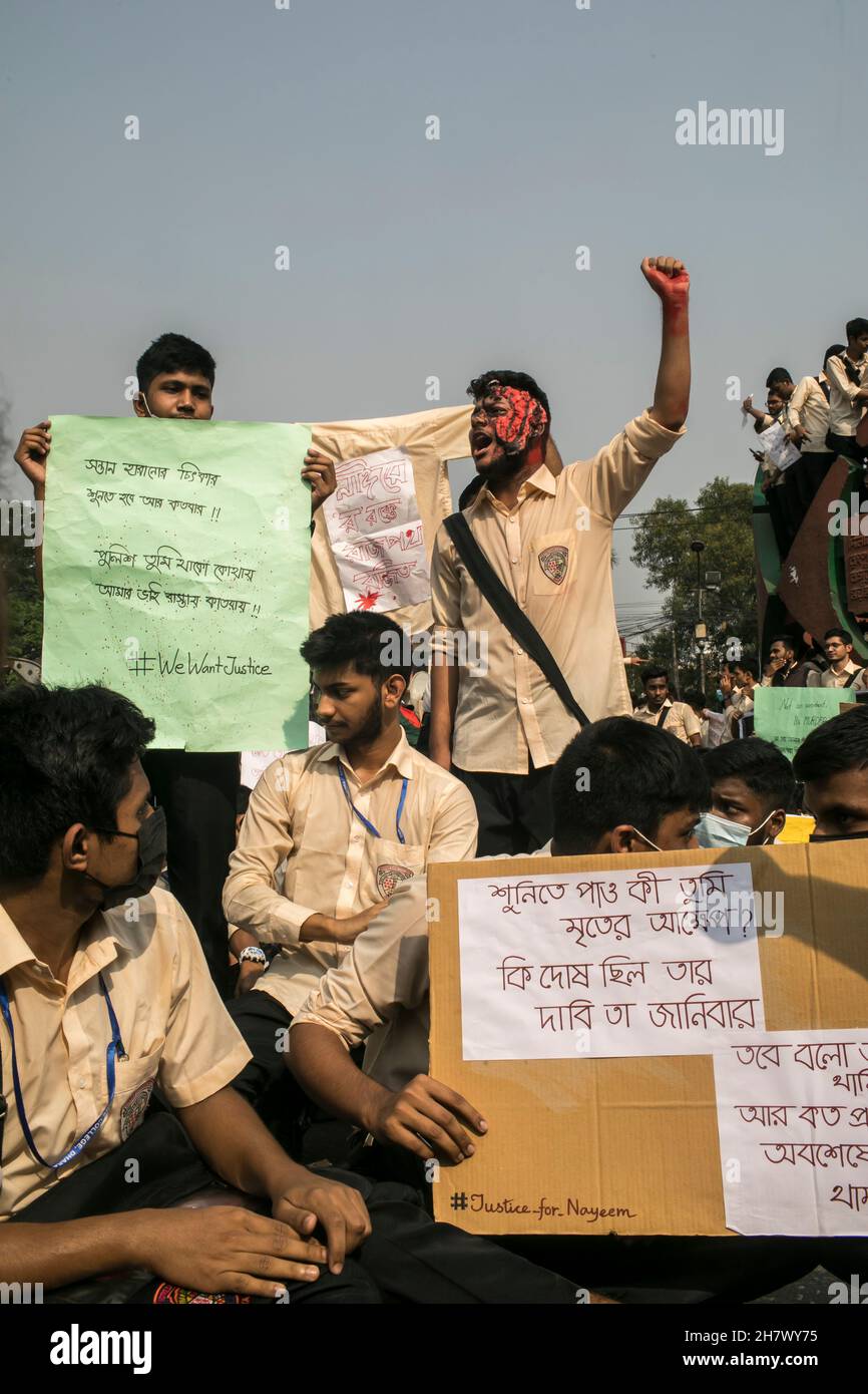 Un étudiant lève une poing et d'autres tiennent des pancartes pendant la manifestation sur la sécurité routière à Dhaka.des étudiants de différents établissements d'enseignement poursuivent leurs manifestations pour la deuxième journée à Dhaka exigeant la sécurité sur les routes à la suite du décès d'un étudiant du Collège notre Dame dans un accident.Nayeem Hasan, étudiant en deuxième année du collège, a été tué mercredi dans un accident de la route. Banque D'Images