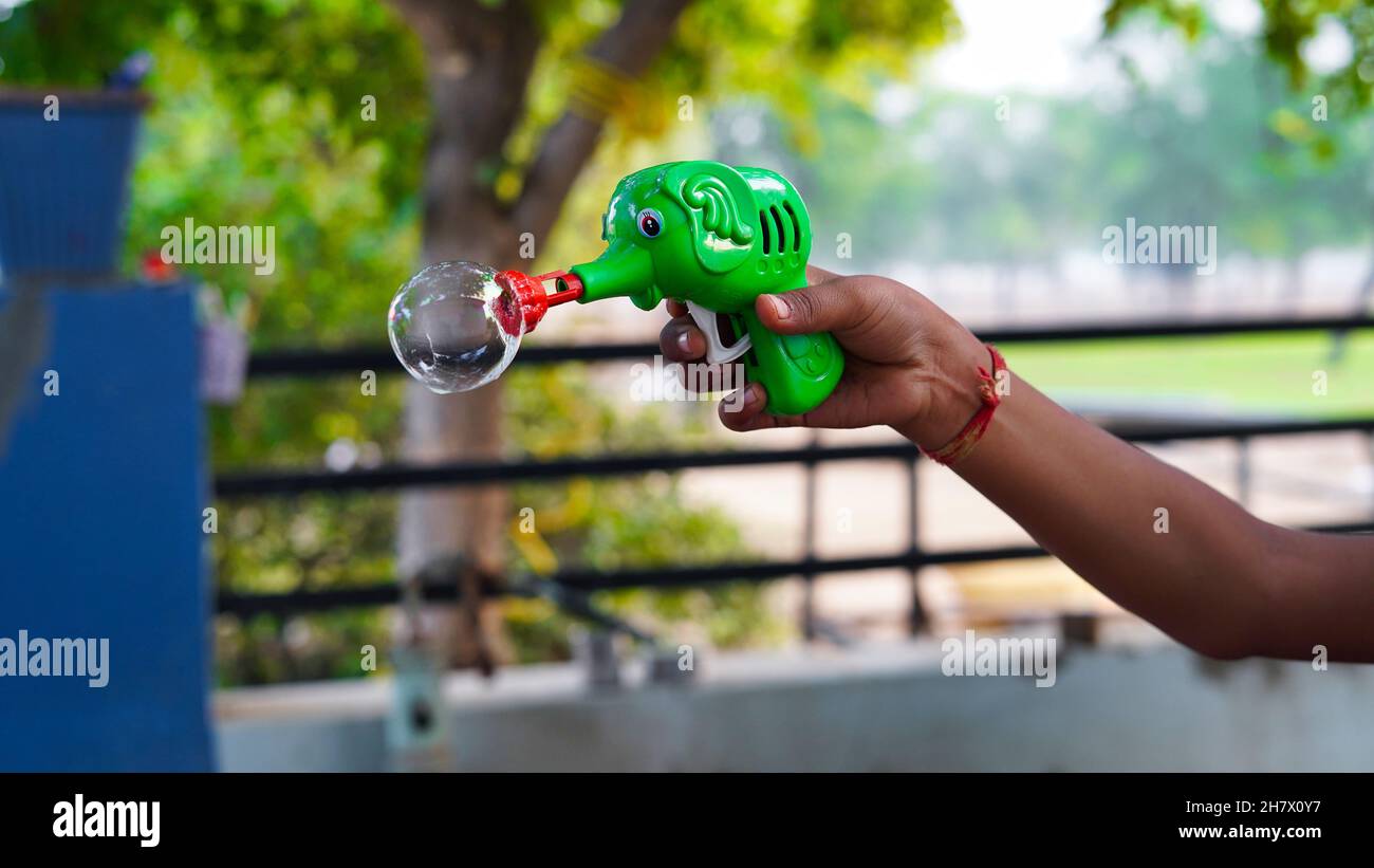 Enfants non identifiés tenant un pistolet souffleur à bulles de savon.Enfants avec souffleur à bulles. Banque D'Images