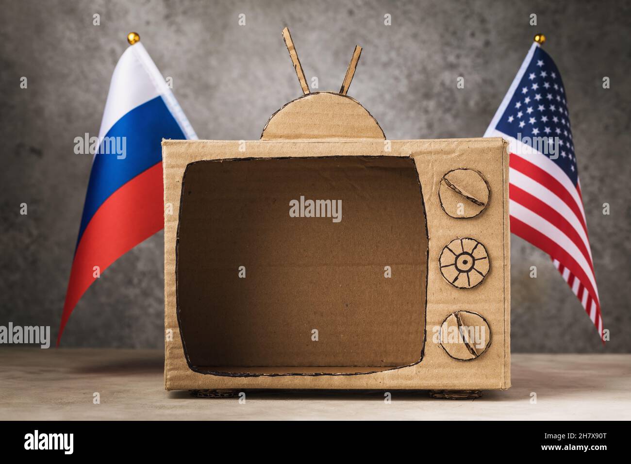 Télévision vide en carton, drapeaux des Etats-Unis et de la Russie sur un fond abstrait, le concept de soumission d'informations dans les pays, un modèle pour Banque D'Images