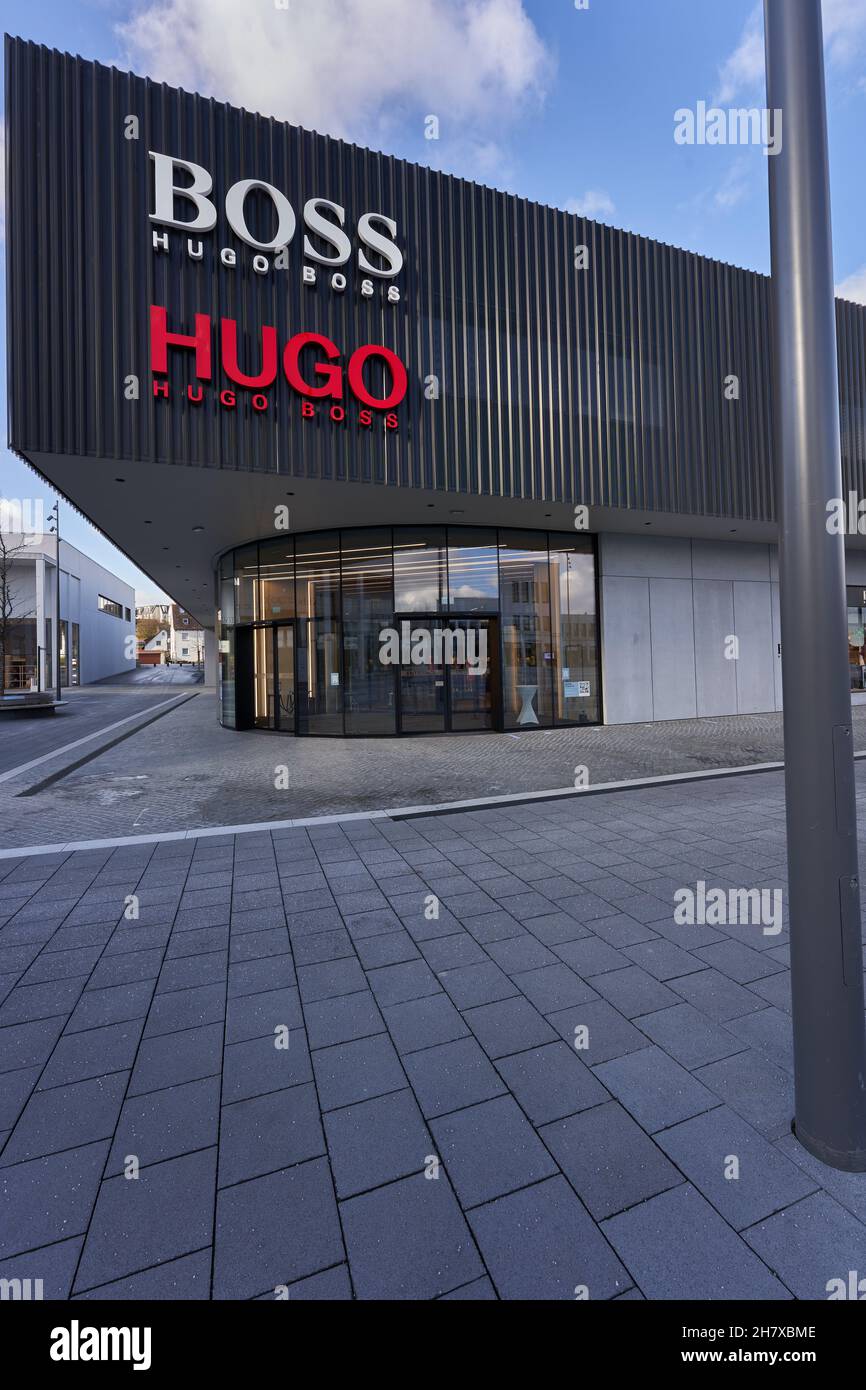 Metzingen, Allemagne - 20 mars 2021: Hugo Boss Outlet Store.Façade  extérieure noire avec logo de la société.Ciel pavé et bleu.Colonne haute  Photo Stock - Alamy