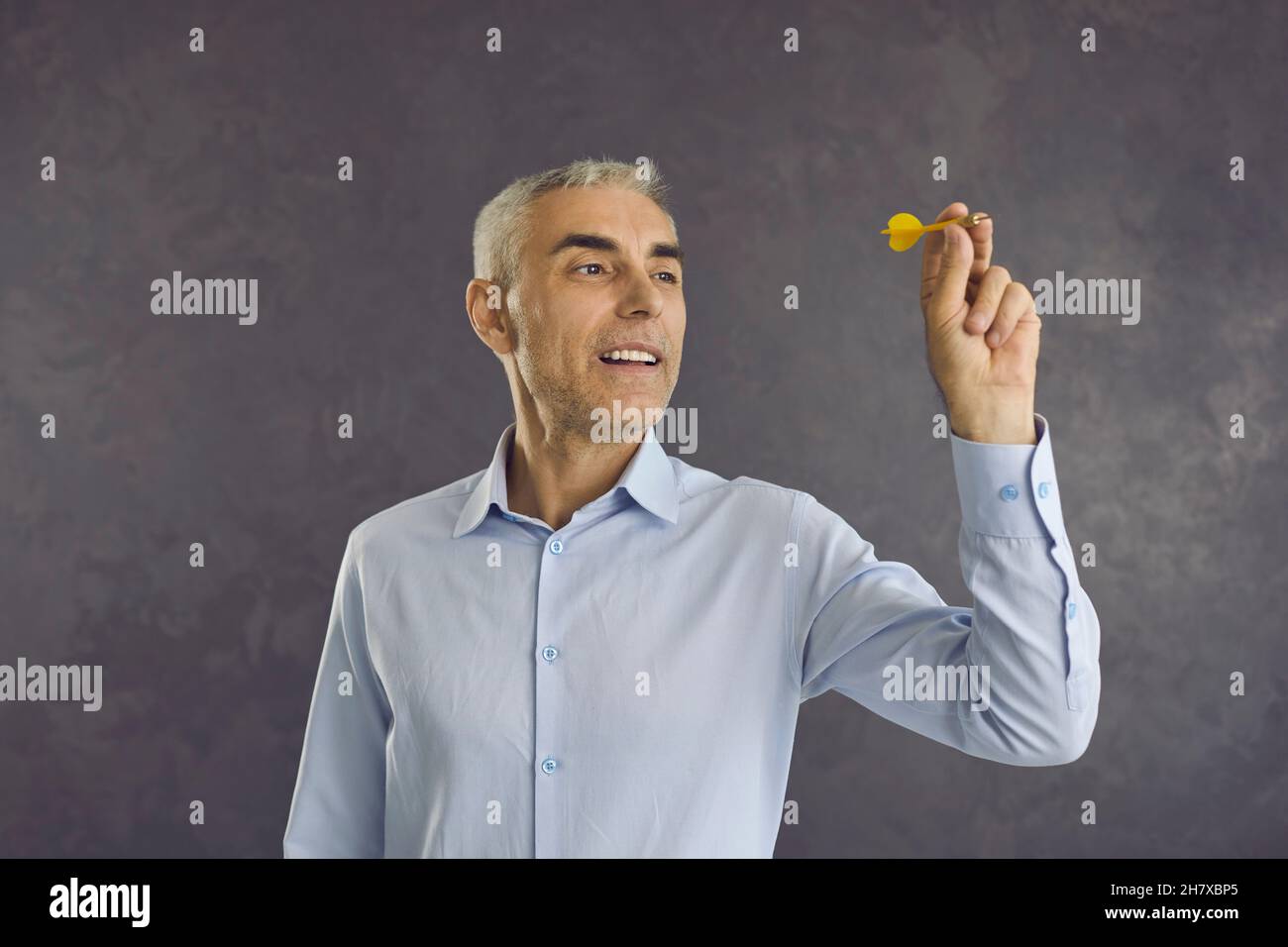 Portrait d'un homme d'affaires senior ou d'un employé d'entreprise visant la flèche de la flèche de la fléchettes à la cible Banque D'Images