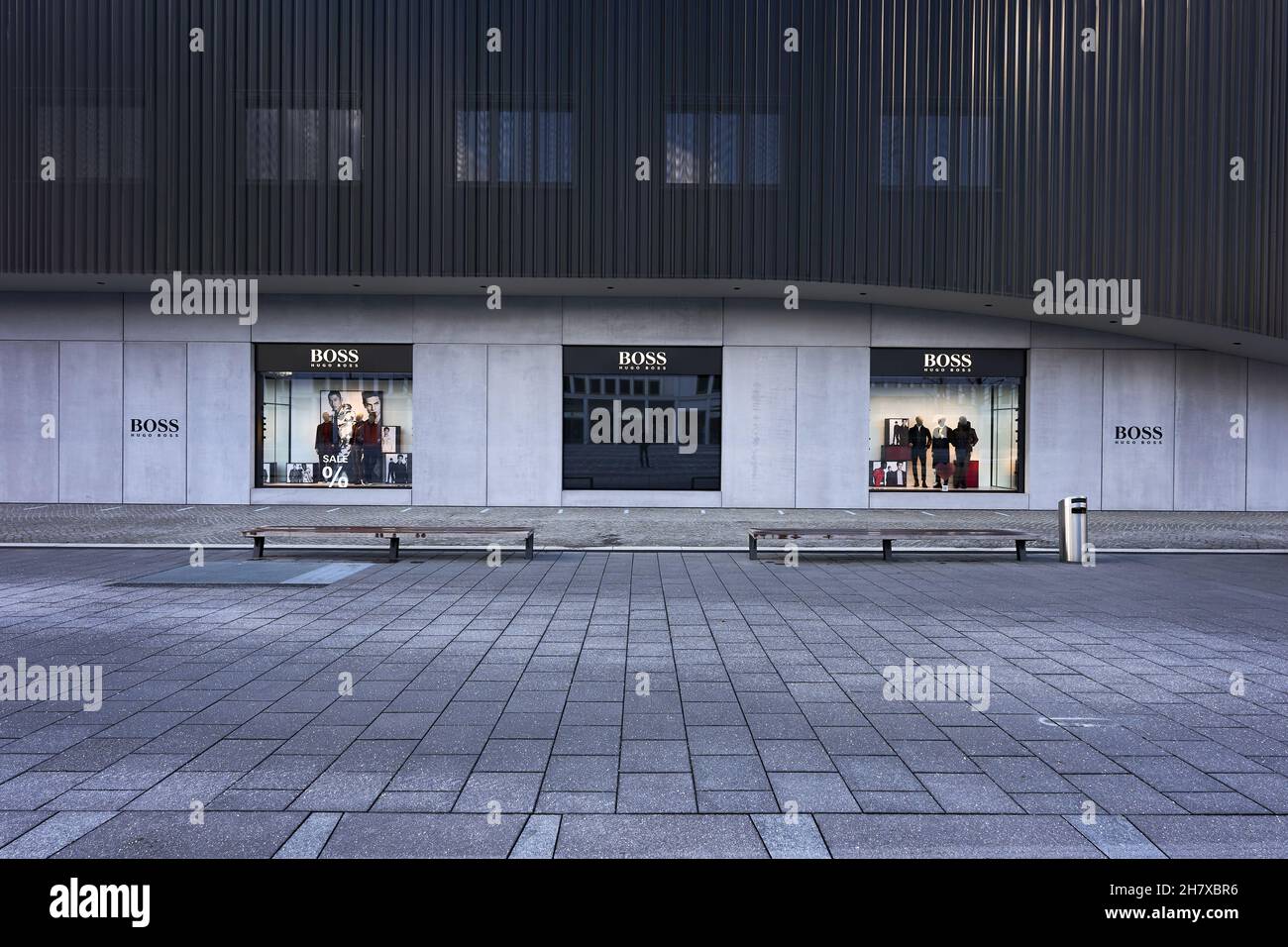 Metzingen, Allemagne - 20 mars 2021: Hugo Boss Outlet Store.Façade  extérieure noire et fenêtre d'atelier.Pavés avec bancs Photo Stock - Alamy