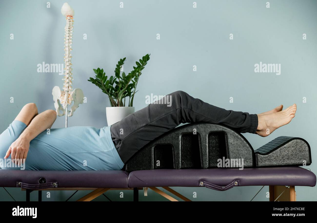 Un homme allongé sur l'arc de pilates en position de repos constructive, si soulagement de douleur articulaire Banque D'Images