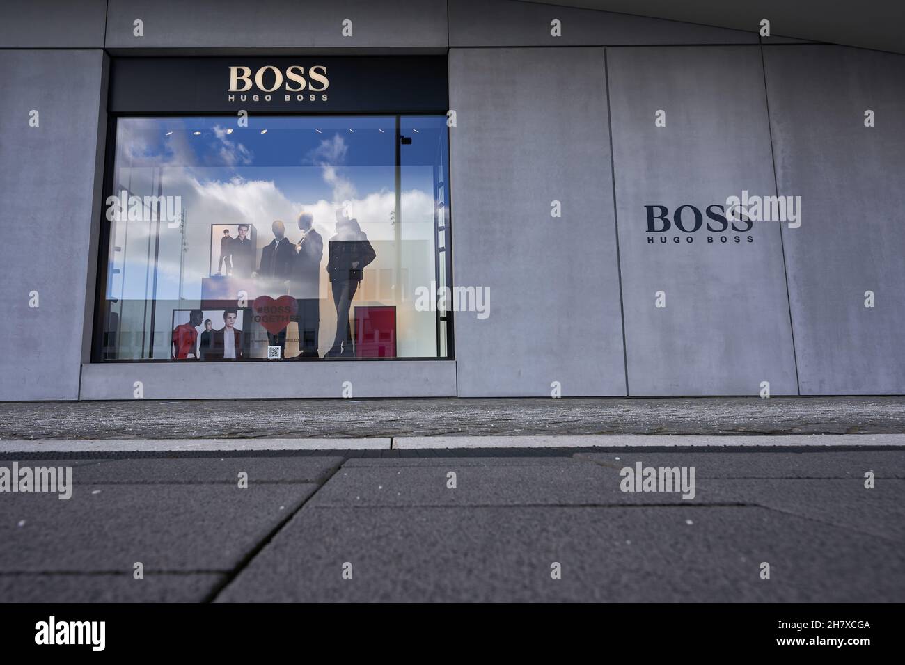 Metzingen, Allemagne - 20 mars 2021: Hugo Boss Outlet Store.Vitrines avec  mannequin sous façade noire.Pavés au premier plan.Face à face Photo Stock -  Alamy