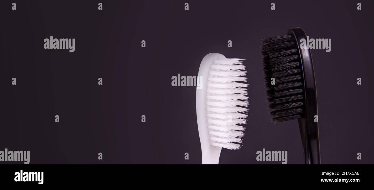 Ensemble de brosses à dents faites à la main isolées sur fond sombre.Brosses à dents en deux couleurs.Noir et blanc Banque D'Images