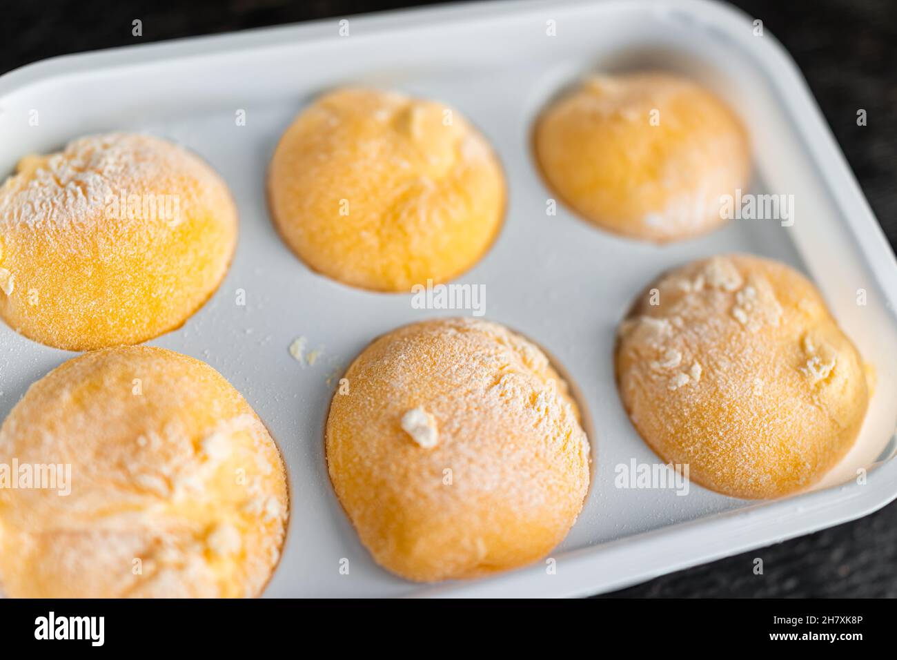 Macro-gros plan de glace surachetée, gâteau de riz mochi glacé, dessert japonais à la mangue ou aux fruits de la passion, saveur tropicale et poudre d'amidon Banque D'Images