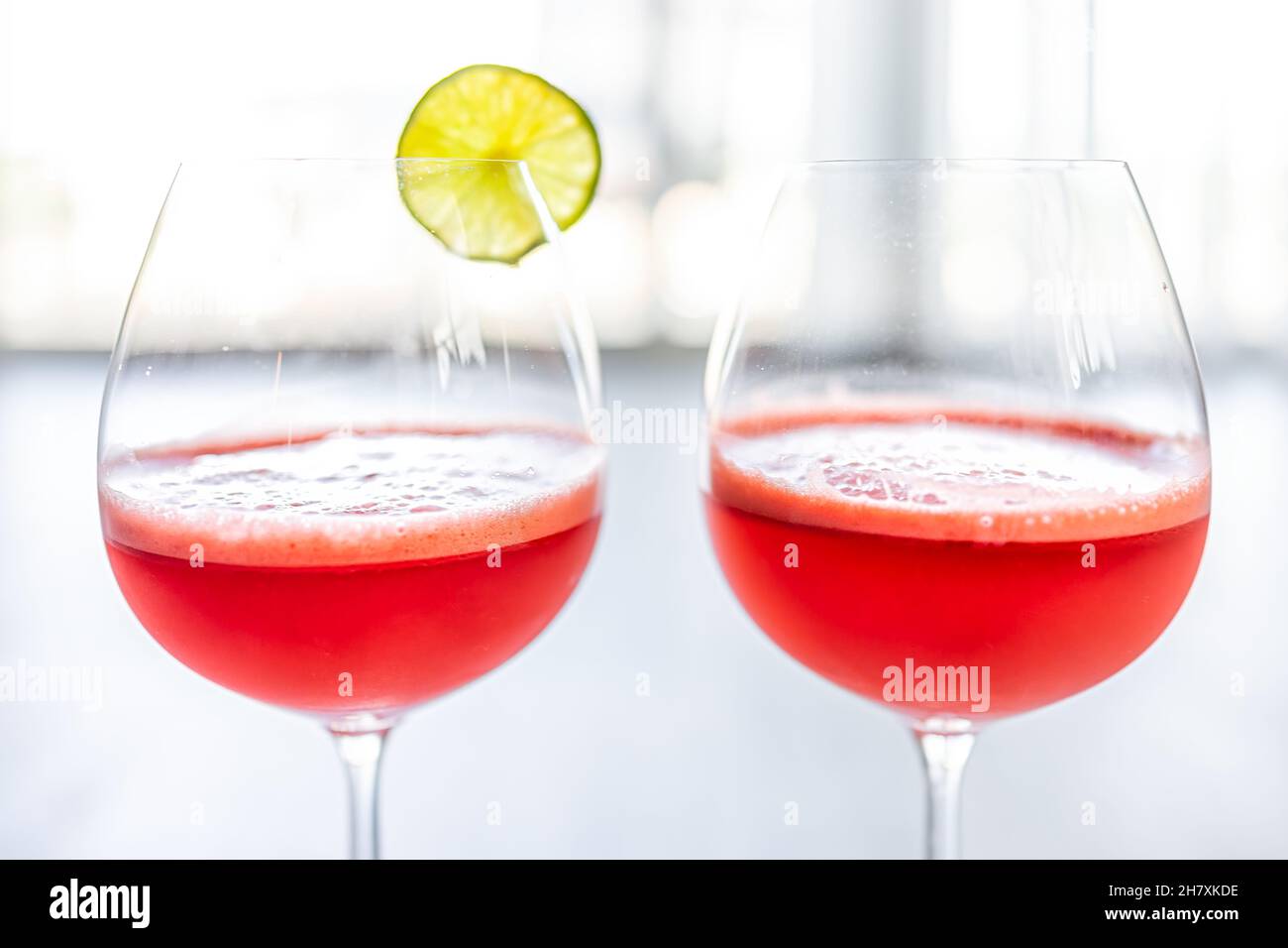 Macro gros plan de deux verres de gobelets de pastèque rouge et de jus de citron vert agua fresca boisson tropicale avec tranche de fruits et fond de bokeh en été Banque D'Images