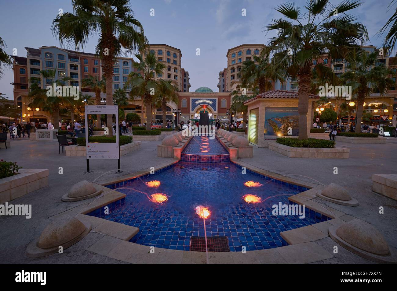 Medina Centrale dans le Peral Doha, Qatar vue au coucher du soleil montrant Souq Almedina en arrière-plan avec fontaine illuminée en premier plan et palmiers Banque D'Images