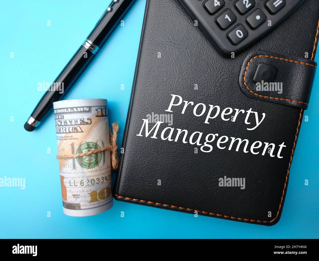 Calculatrice, bloc-notes, stylo, rouleau de papier argent et le mot gestion de propriété Banque D'Images