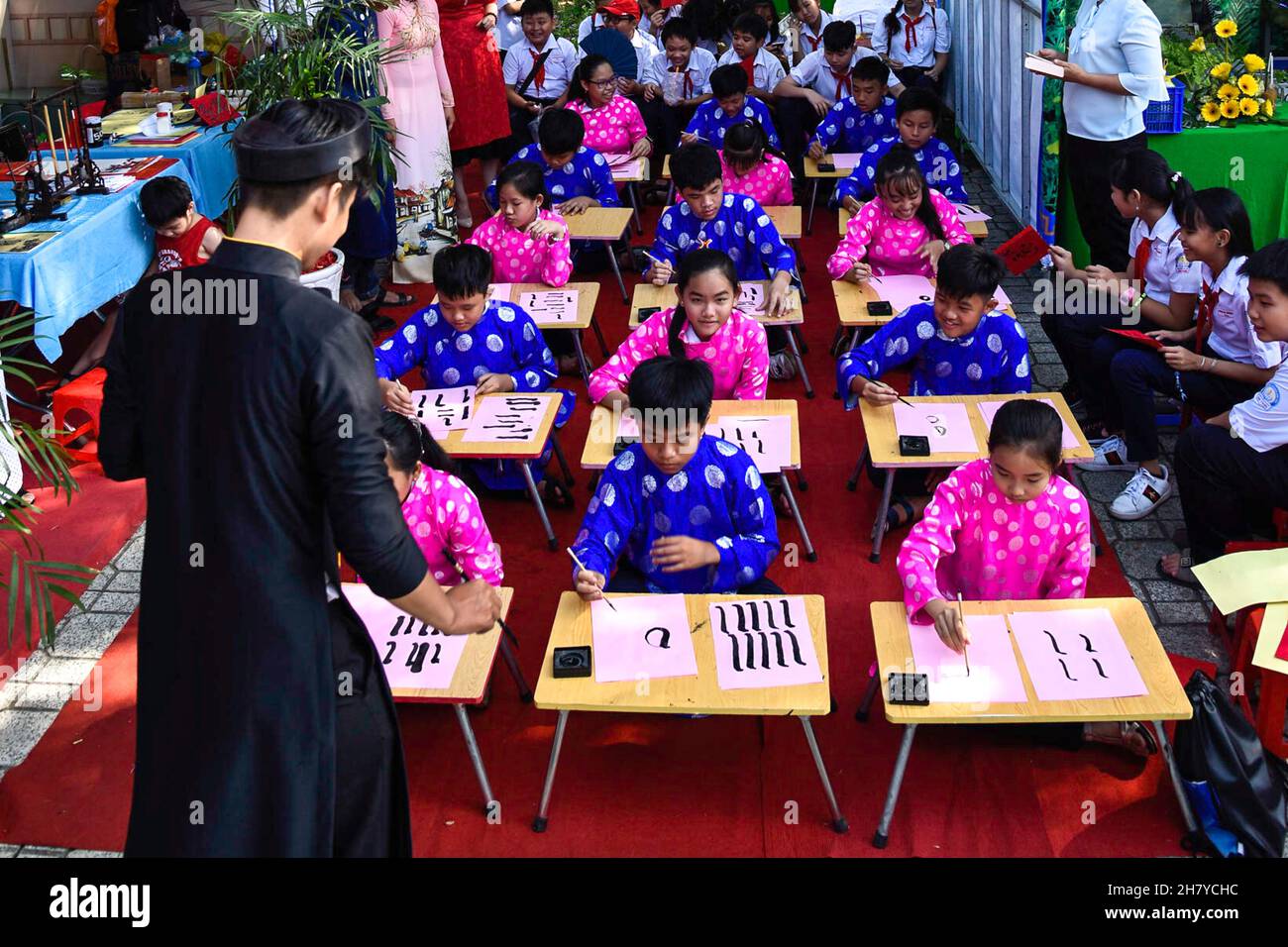 Les enfants vietnamiens apprennent à écrire la calligraphie à l'occasion des vacances de Tet. Banque D'Images