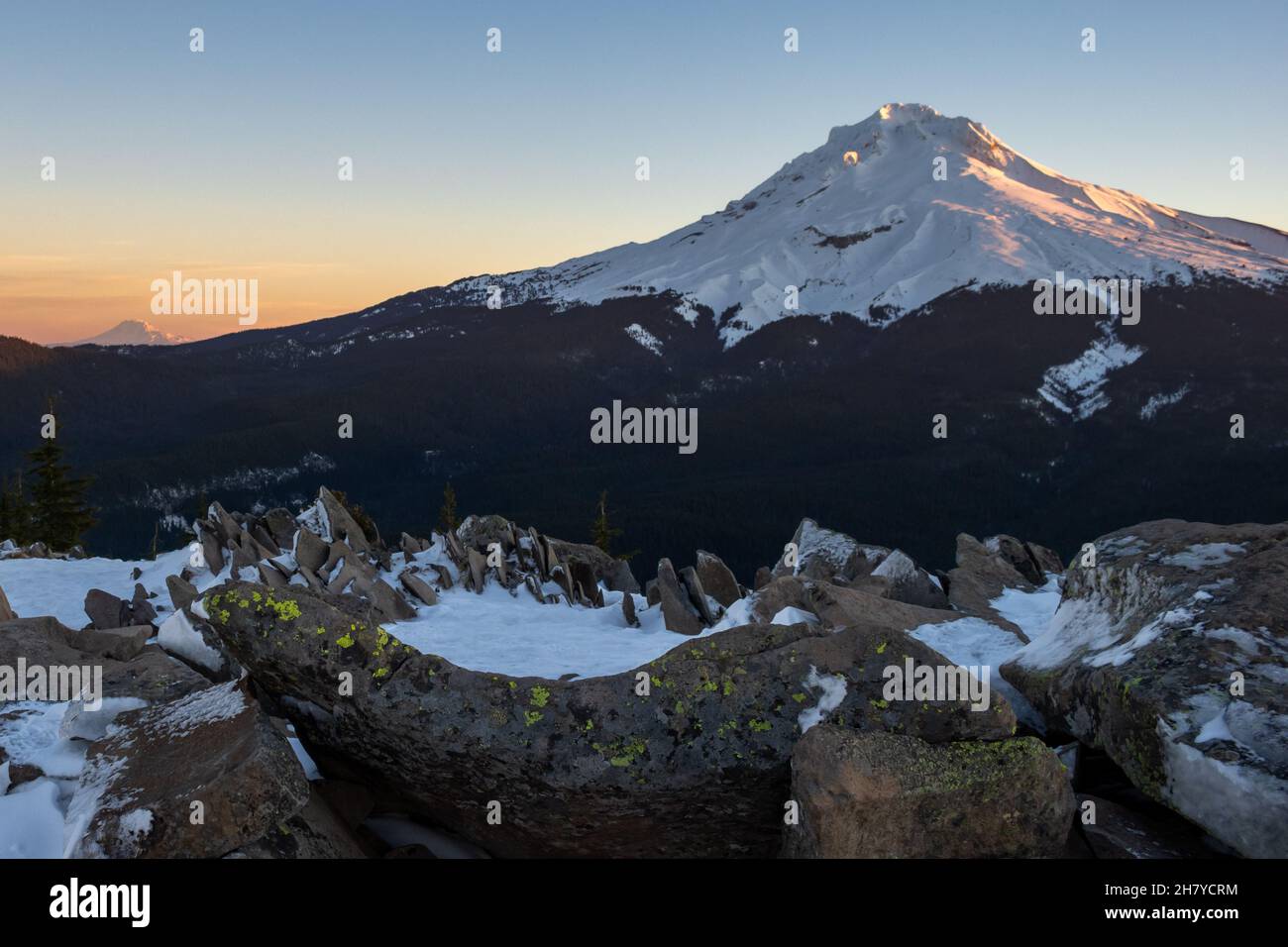 Vue sur un sommet de montagne enneigé, dans les rochers de montagne en premier plan dans la neige, Mt.Hood National Forest Banque D'Images