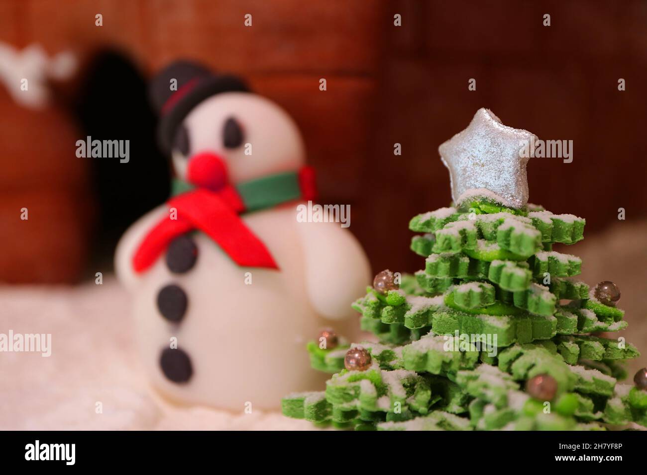 Gros plan du Royal Icing Christmas Tree avec Fondant Snowman flou en toile de fond Banque D'Images