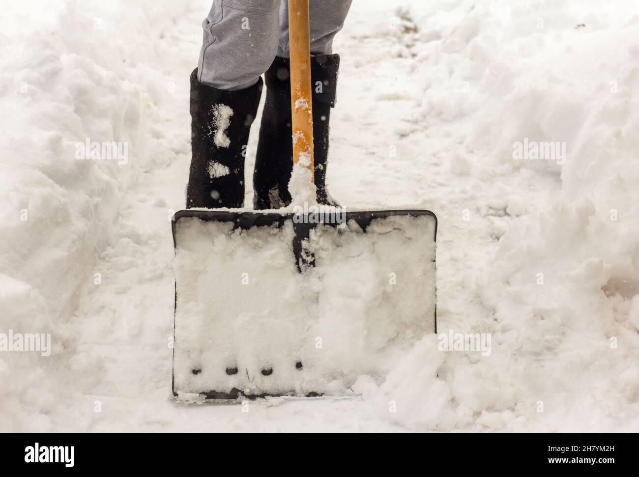Un homme nettoie les chemins dans la cour de la neige Banque D'Images