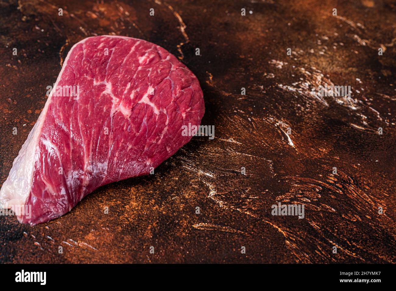 Bœuf cru coupé ou steak de viande de sirloin sur la table de boucher. Arrière-plan sombre. Vue de dessus. Copier l'espace Banque D'Images