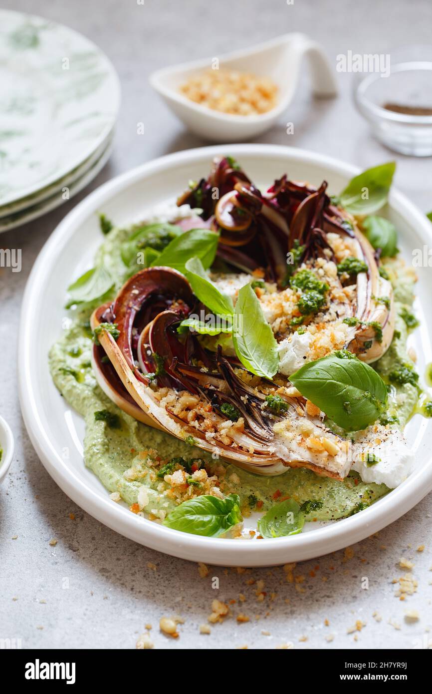 Salade de radicchio rôtie avec feta, tahini vert, pignons de pin et pesto au basilic.Radicchio rosso di trévise tardivo, chicorée rouge italienne.Repas santé reci Banque D'Images