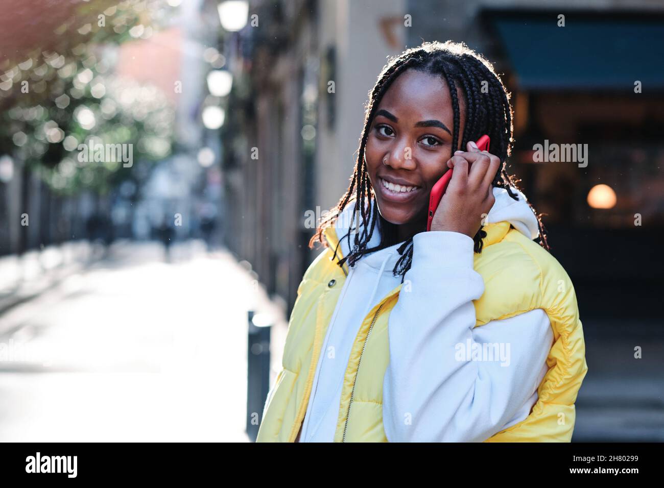 Femme parlant au téléphone en étant debout à l'extérieur. Banque D'Images