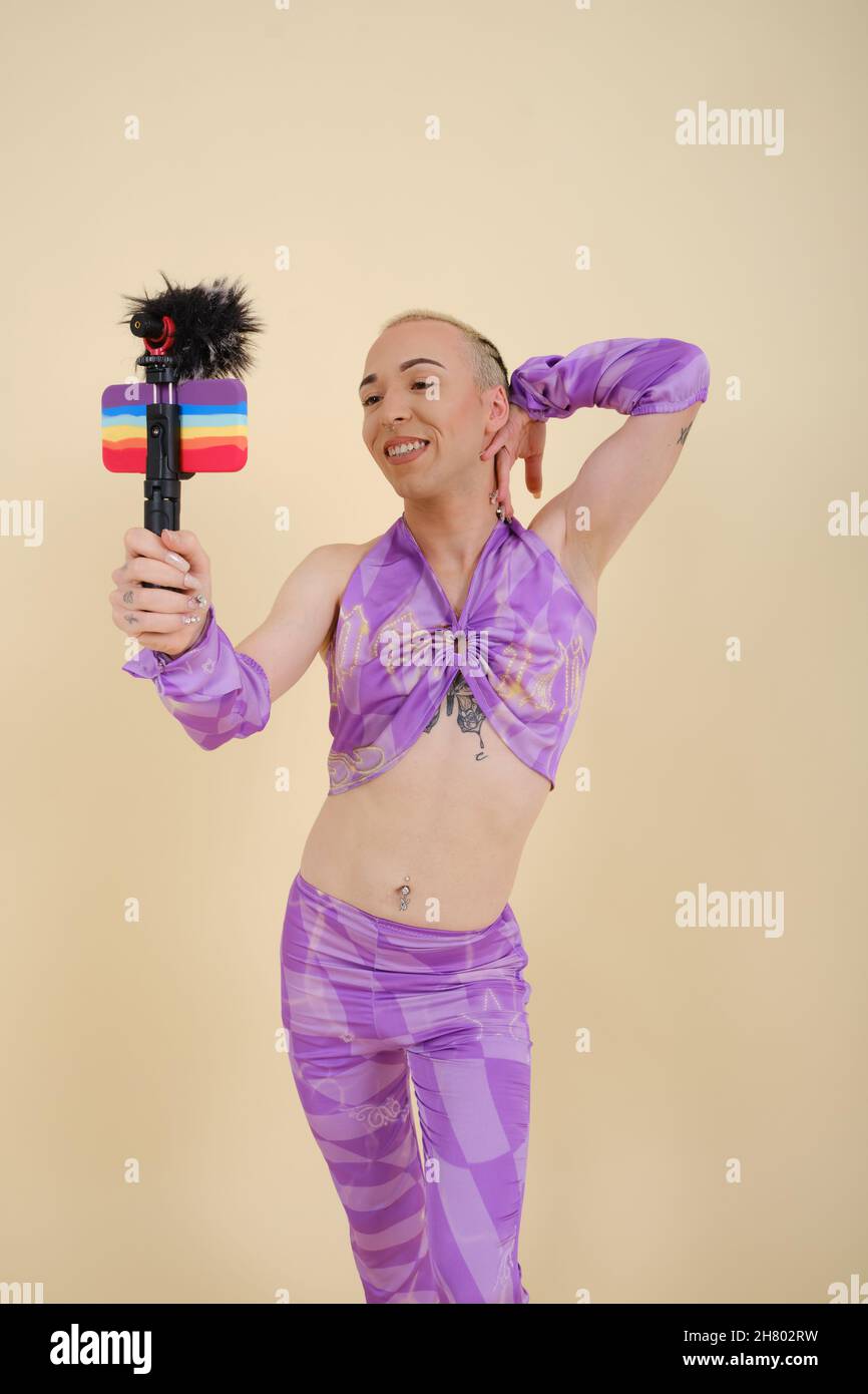 Bonne personne non binaire enregistrant une vidéo vlog ou streaming en direct avec un téléphone portable. Banque D'Images