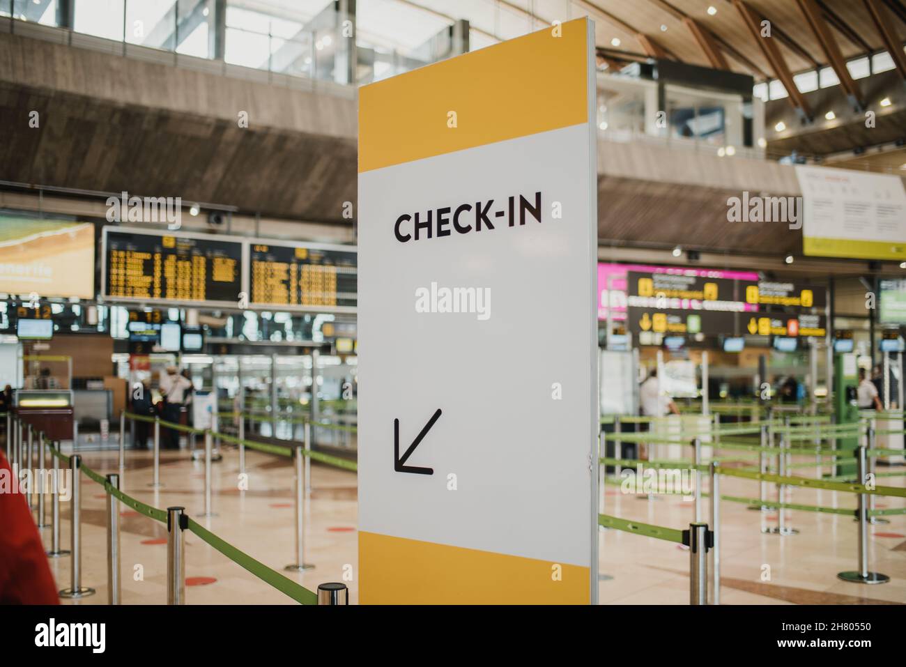 Enregistrement blanc dans le panneau de direction près des comptoirs avec piliers en métal dans l'aéroport public lumineux moderne avec horaire des vols sur des panneaux de signalisation contemporains Banque D'Images