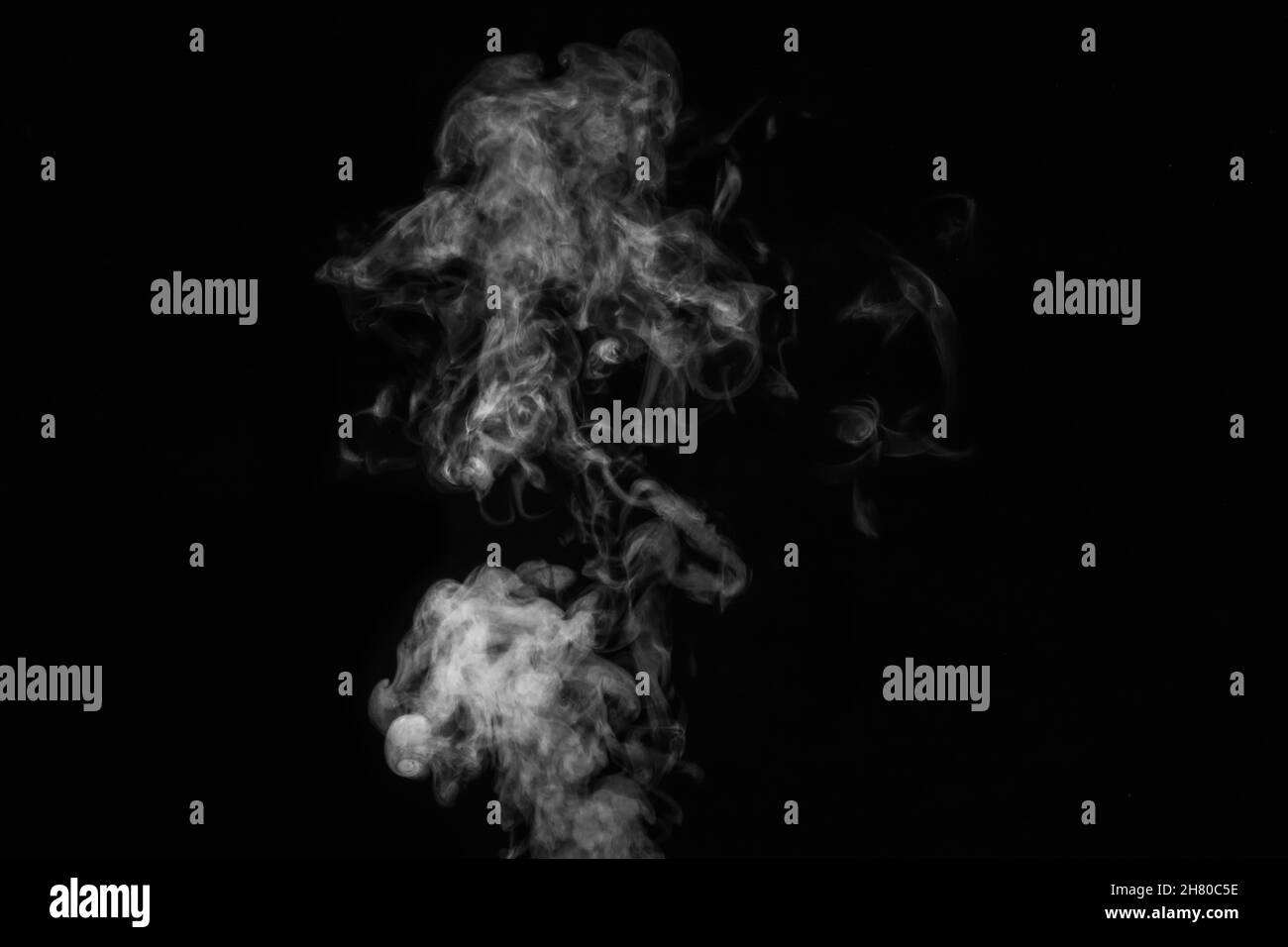 Fragment de fumée blanche à la vapeur bouclés isolée sur fond noir, gros plan.Arrière-plan abstrait, élément de conception Banque D'Images