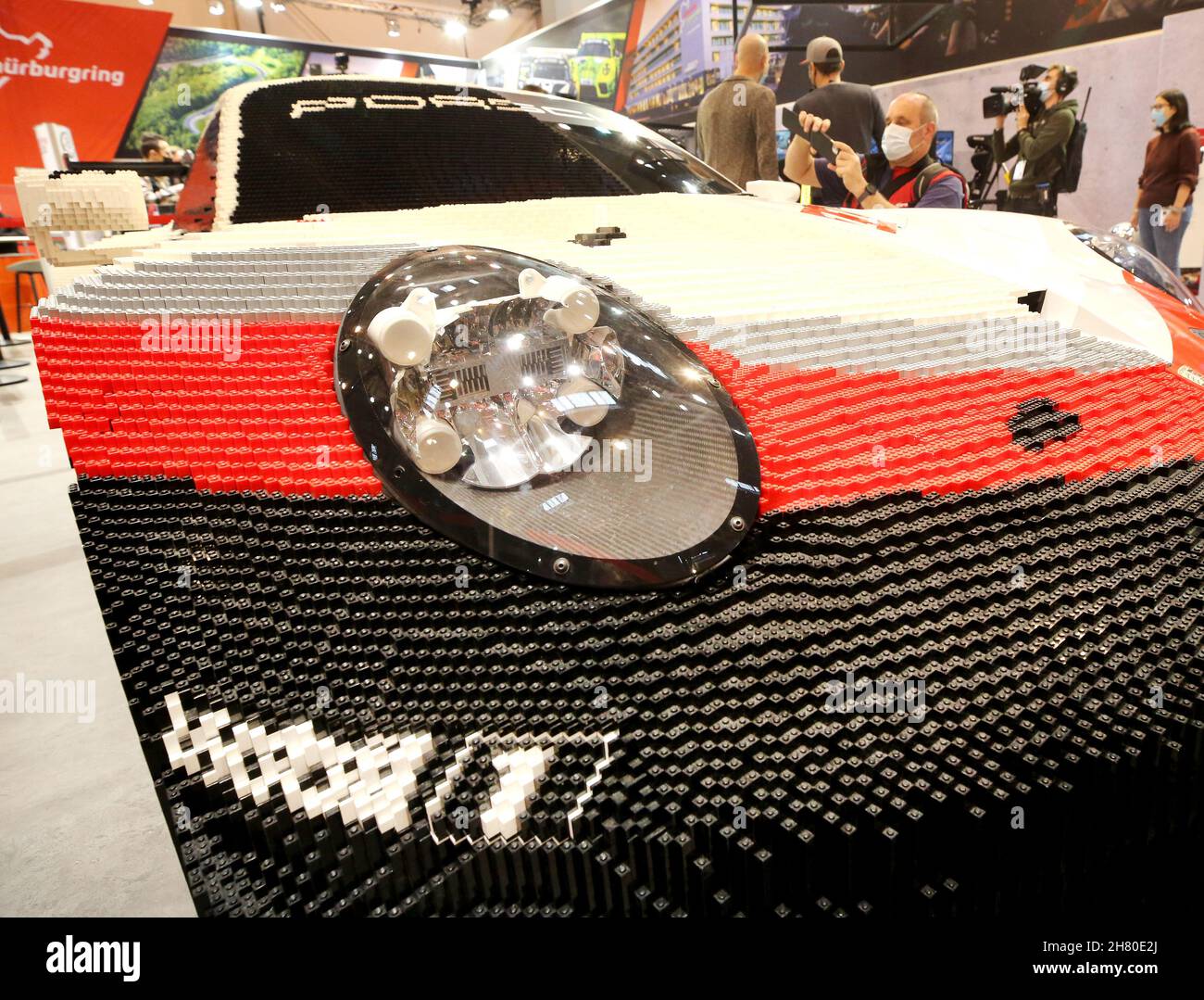 Essen, Allemagne.26 novembre 2021.Une Porsche 911 RSR, dont la moitié du corps est faite de briques Lego, est photographiée par un visiteur professionnel au salon de l'tuning 'Essen Motor Show'.Environ 400 exposants souhaitent présenter des véhicules et des accessoires dans huit halls de 27.11 à 05.12.2021.Crédit : Roland Weihrauch/dpa/Alay Live News Banque D'Images