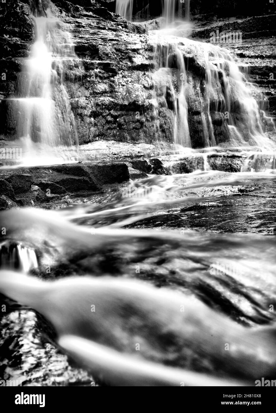 L'eau coule sur des rochers, la photographie en noir et blanc Banque D'Images