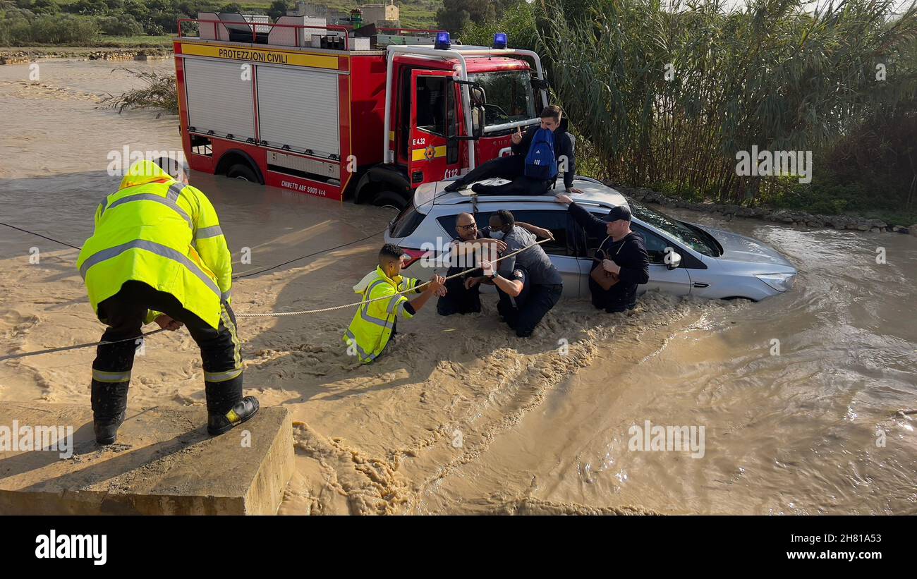 Salina, Malte.25 novembre 2021.Les sauveteurs transfèrent des personnes piégées dans une voiture alors que les inondations frappent Salina, Malte, le 25 novembre 2021.Credit: Jonathan Borg/Xinhua/Alay Live News Banque D'Images