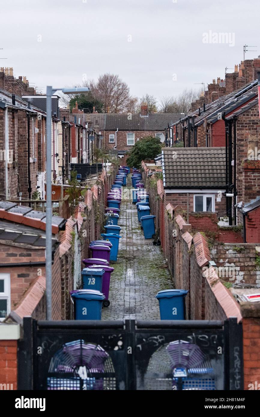 Des bennes à roulettes alignées dans une allée entre les rangées de maisons en terrasse - Liverpool, Angleterre, Royaume-Uni Banque D'Images
