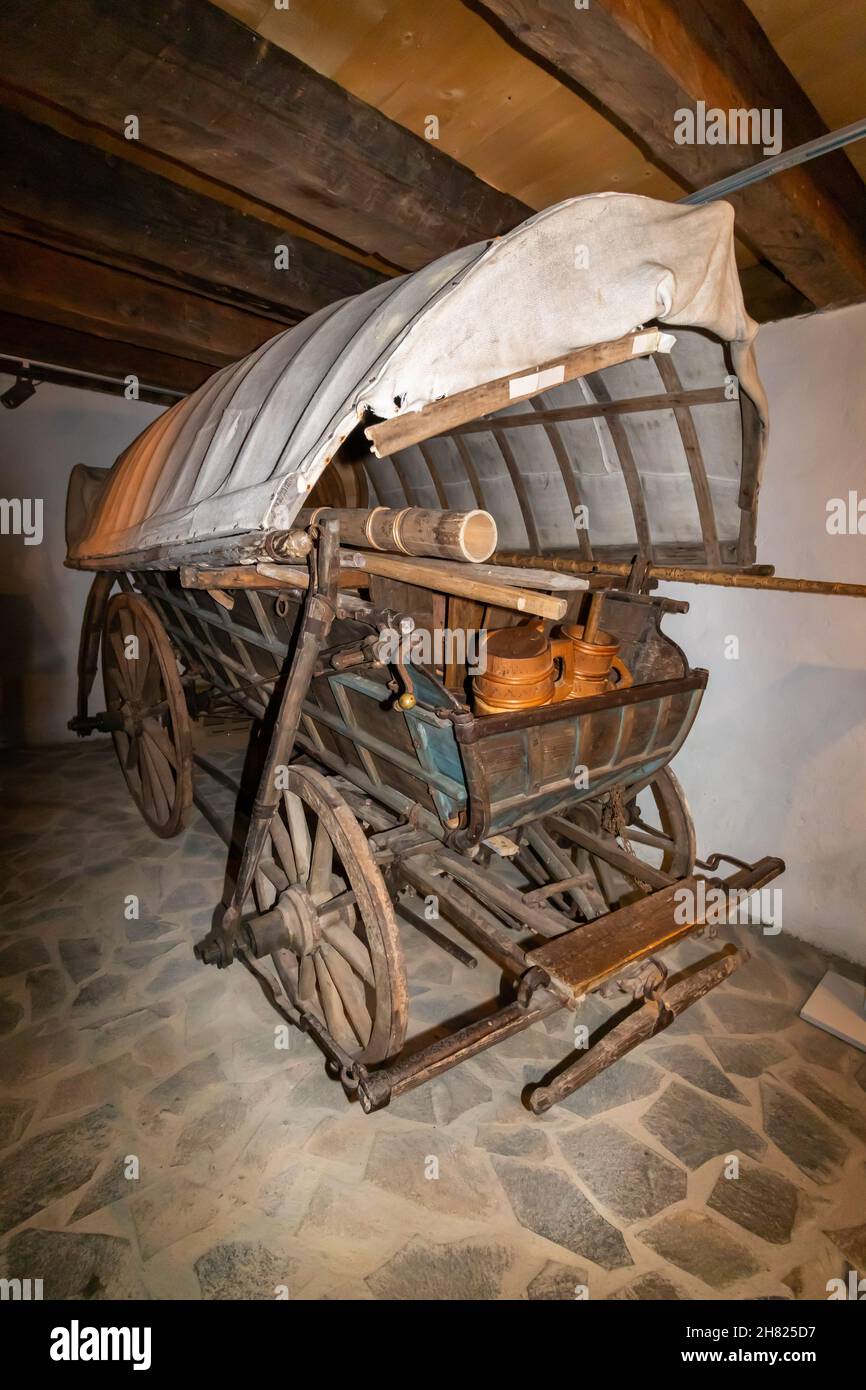 Photo arrière d'un chariot traditionnel avec roues en bois, recouvert de matériau et chargé de divers objets en bois Banque D'Images