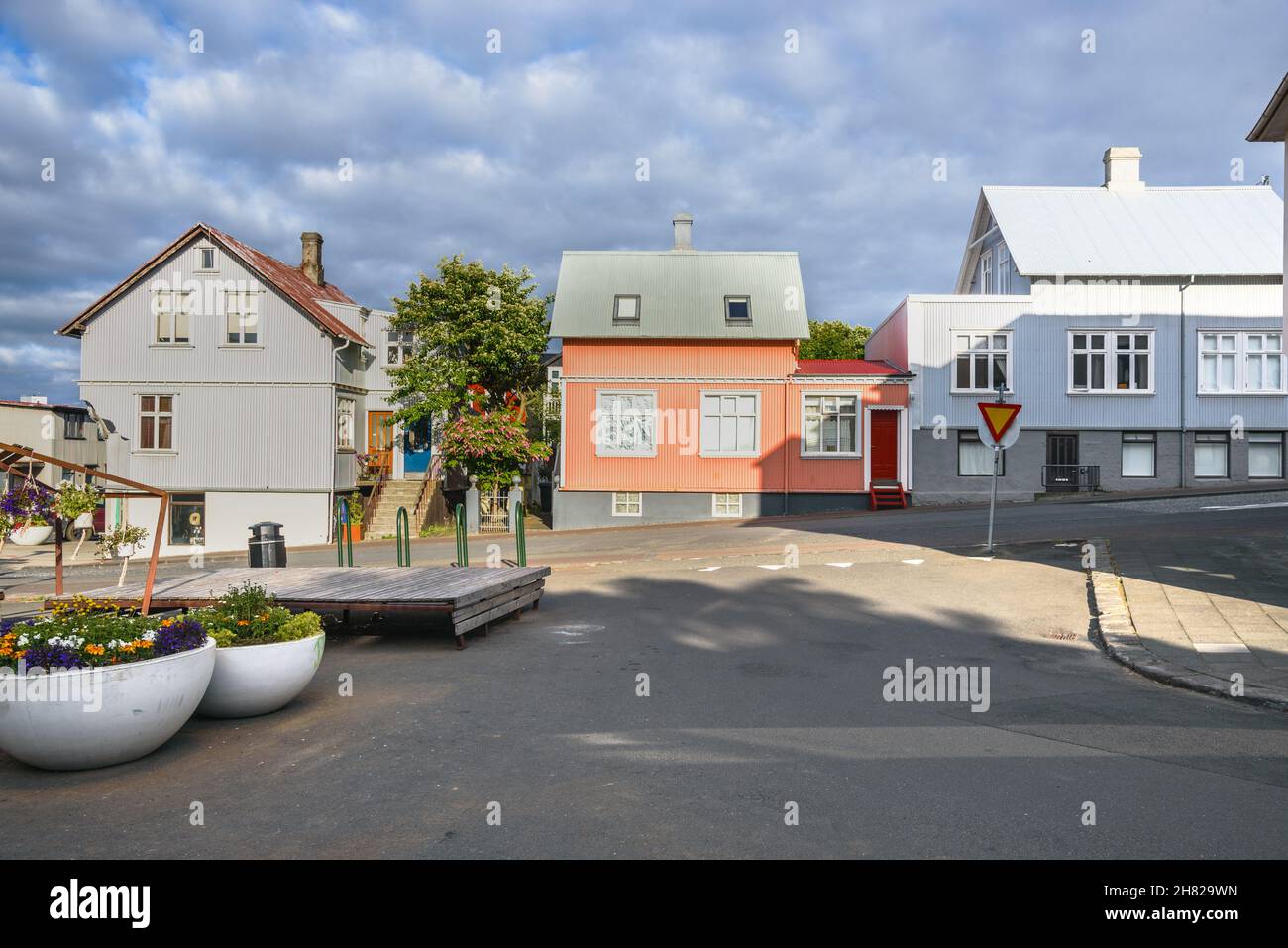 Maisons en métal ondulé le long d'une rue sous les nuages de tempête Banque D'Images