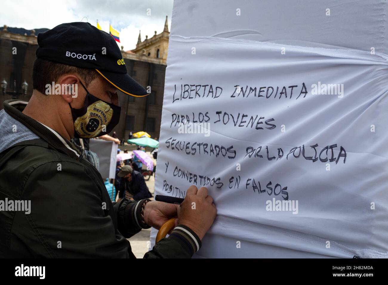 Un manifestant écrit un message pour protester contre les jeunes manifestants arrêtés illigalement par la police lors de manifestations convoquées par des syndicats contre le gouvernement du président Ivan Duque Marquez, à Bogota, en Colombie, le 25 novembre 2021. Banque D'Images