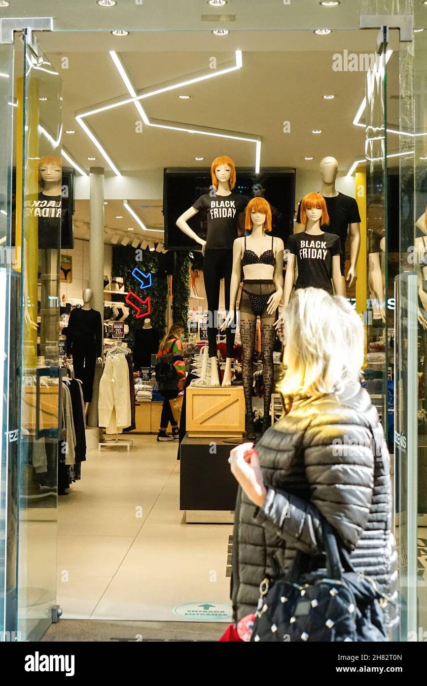 Malaga, Espagne.26 novembre 2021.Une femme regarde le mannequin dans une  vitrine Bershka lors d'une vente du Black Friday à Malaga.en 2021, le  commerce en ligne a augmenté de 71% après que les