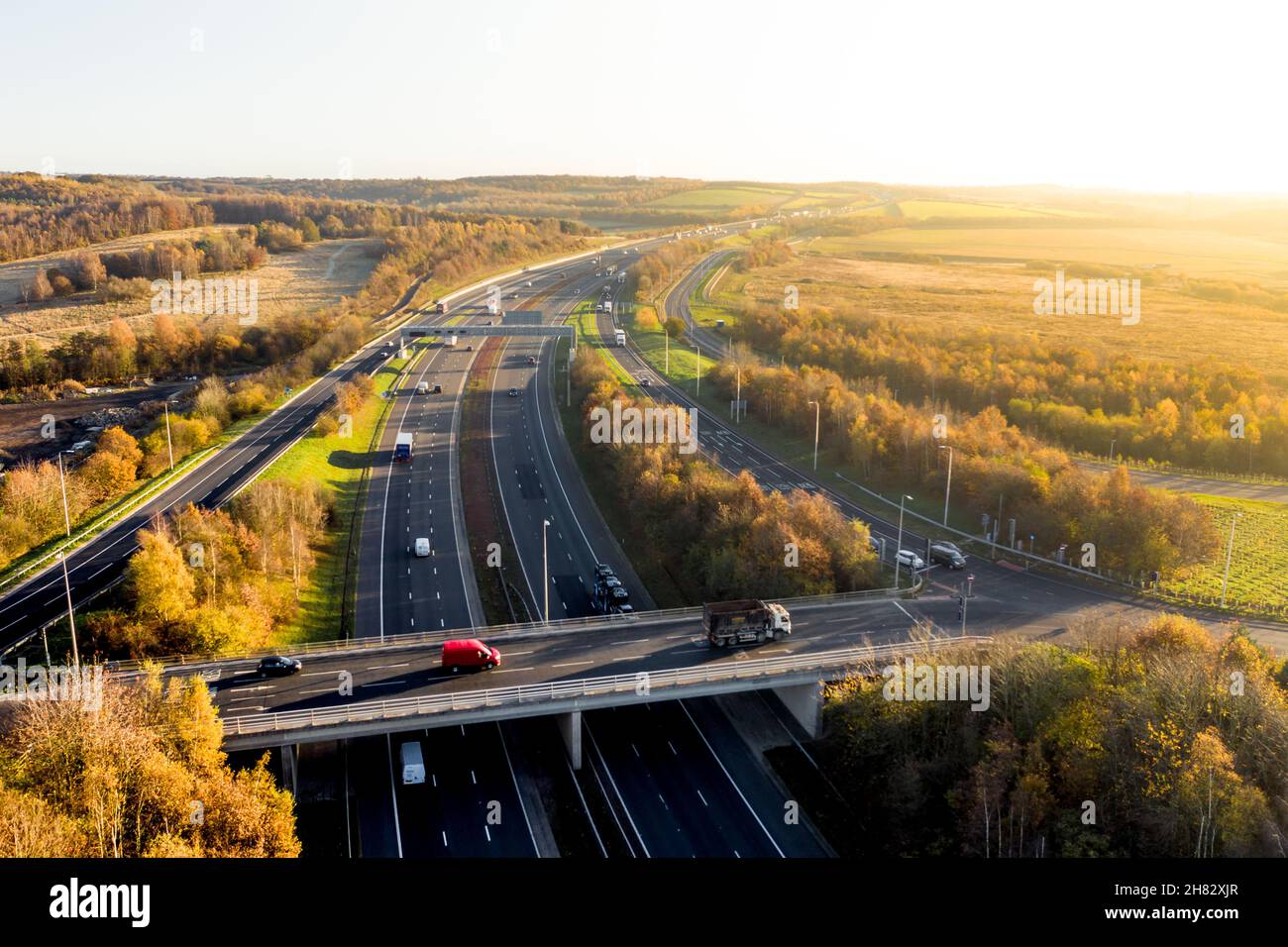 Vue aérienne sur le paysage d'une autoroute britannique et pont traversant la campagne pittoresque au coucher du soleil Banque D'Images