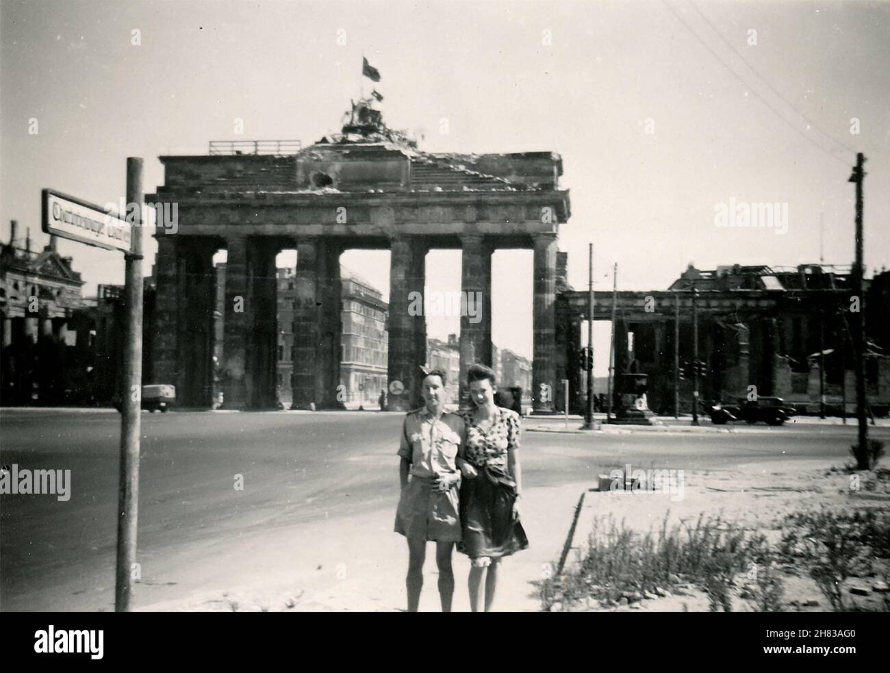 En août 1947, le pilote-officier Browne de la RAF a visité Berlin et a emmené une compagne femelle pour une visite de la ville.Ici, ils sont posés devant la porte de Brandebourg ravagée par la bataille.La fille est inconnue, peut-être une serveuse allant par son tablier.P/O Browne s'est envolé pour Berlin Gatow le 12 août 1947 et s'est envolé pour RAF Bückeberg le 19 août 1947. Banque D'Images