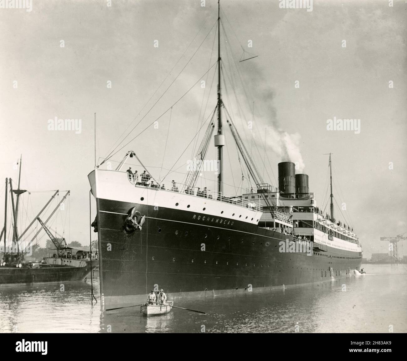 Photo dans les années 1920.SS Rochambeau était un paquebot transatlantique français de la Compagnie générale transatlantique (CGT).Elle a été lancée en 1911 et abandonnée en 1934.La photo montre les gens dans un bateau à rames le long du bateau alors qu'elle est assise dans le port. Banque D'Images