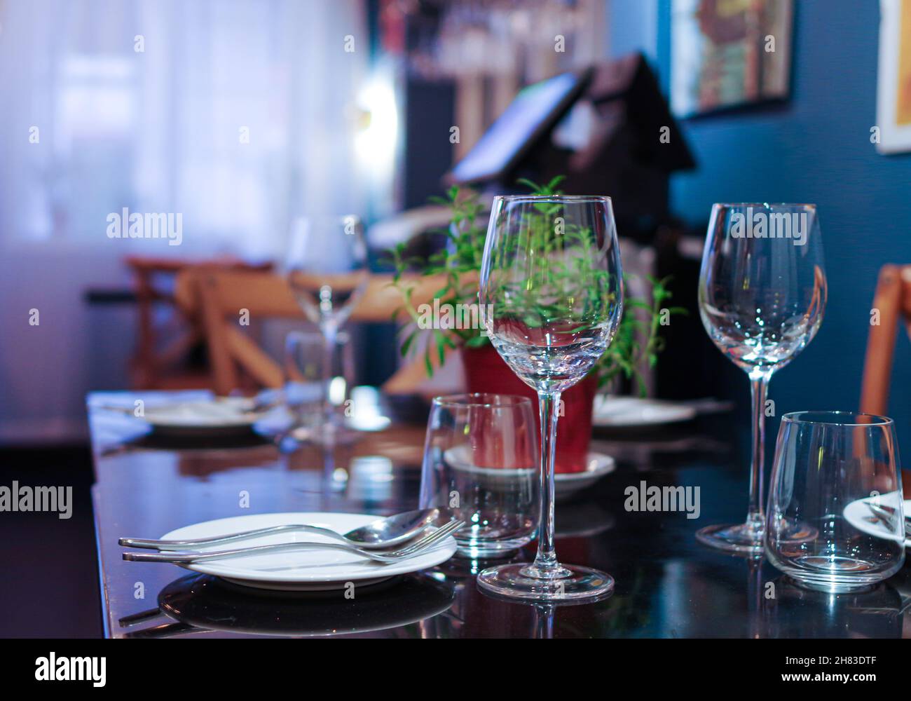 Verres à vin sur une table noire près de la fenêtre avec un rideau fin Banque D'Images