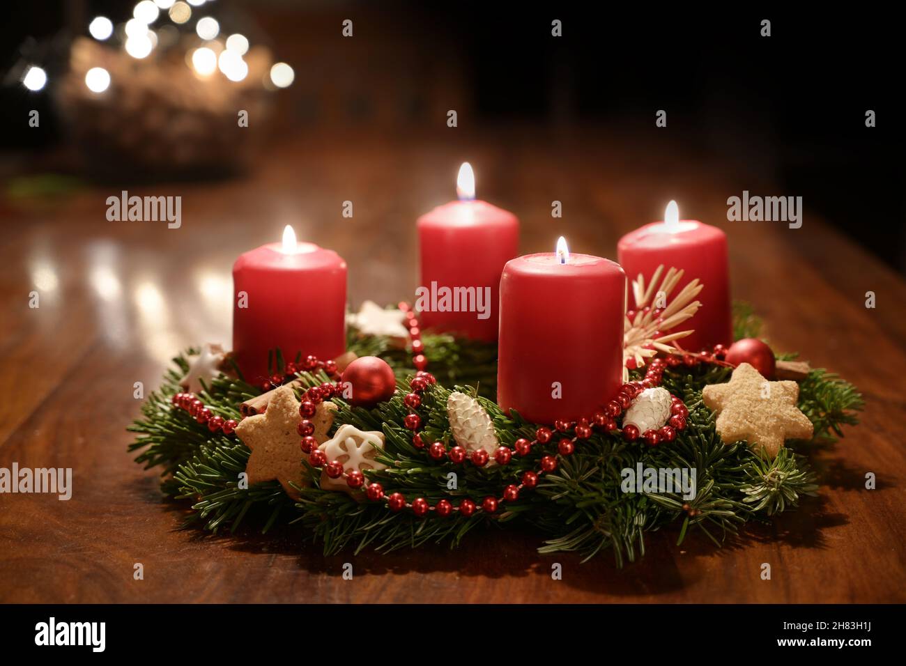 Quatrième Avent - couronne de l'Avent décorée de branches de sapin avec des bougies rouges sur une table en bois à l'époque avant Noël, bokeh festif dans le TH Banque D'Images