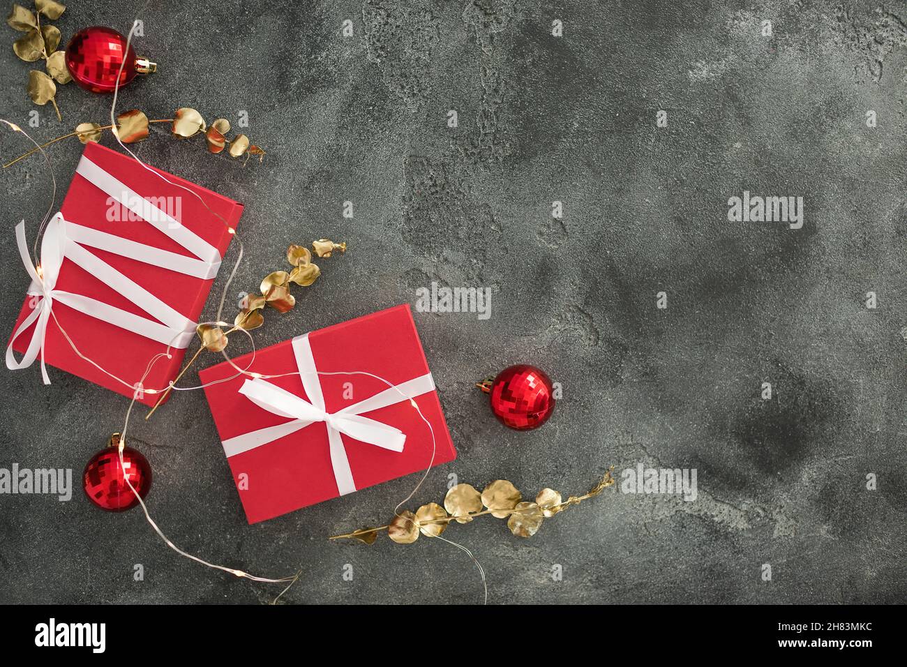 Composition de Noël avec branches dorées, cadeaux et décoration dans le noir.Pose à plat Banque D'Images