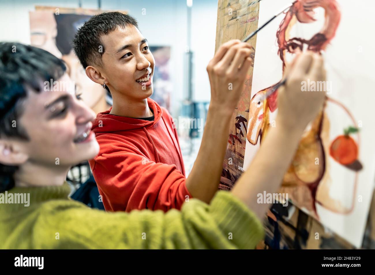 Les jeunes étudiants peignent sur toile pendant la leçon à la faculté des arts université - concept d'apprentissage et d'éducation Banque D'Images